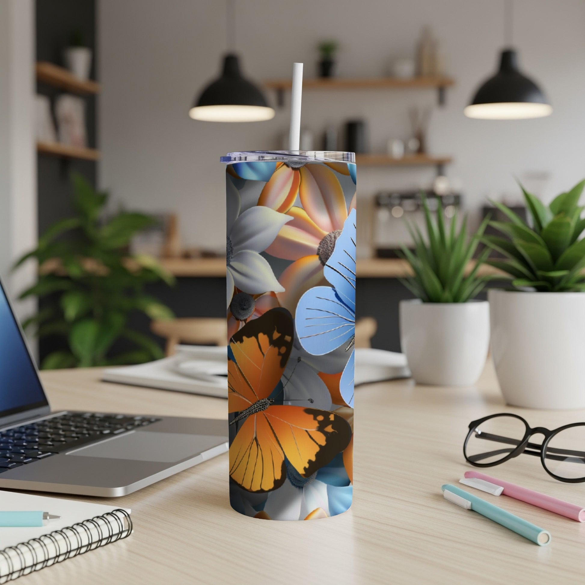 Tumbler with colorful butterflies and flowers on a desk.