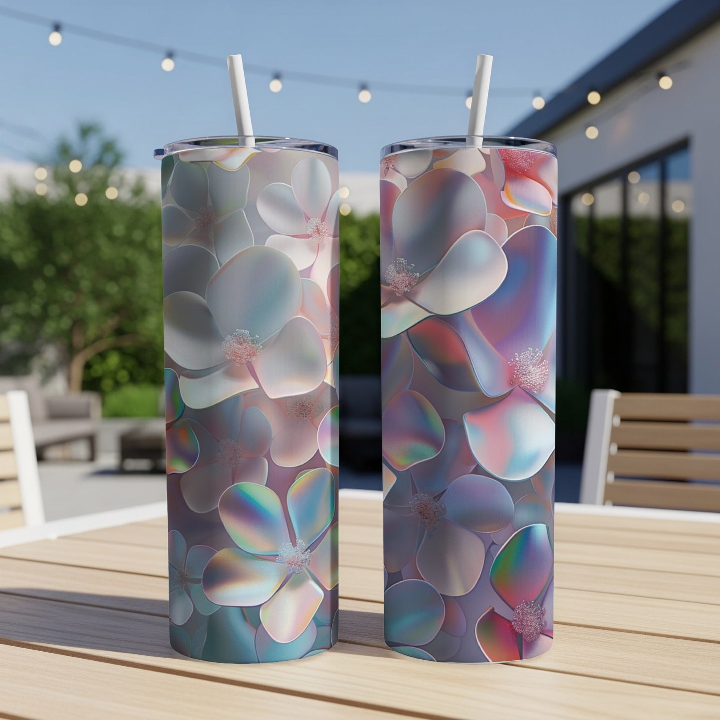 Two iridescent floral tumblers with straws on a wooden table.