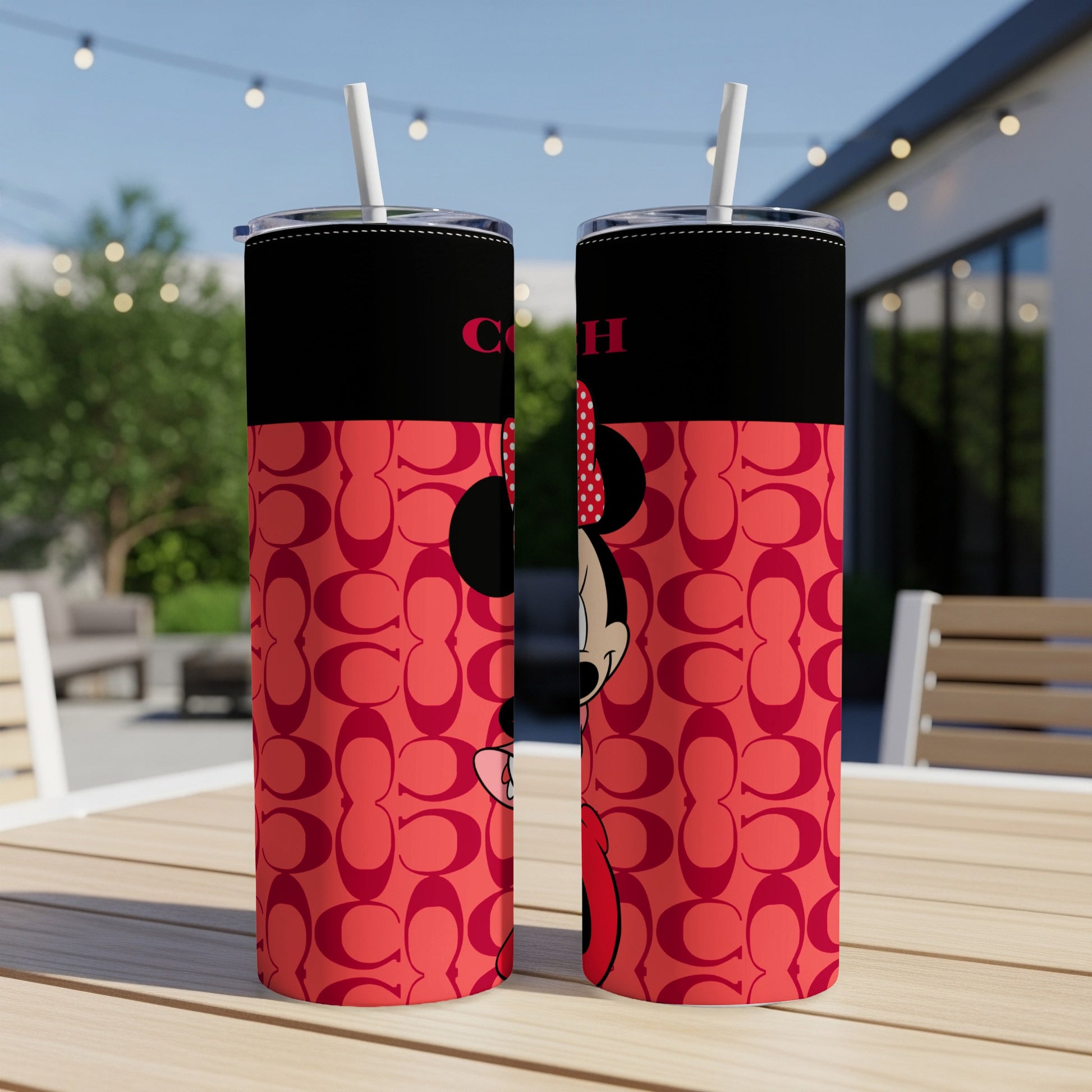 Two tumblers with Minnie Mouse and Coach logo pattern on a table.