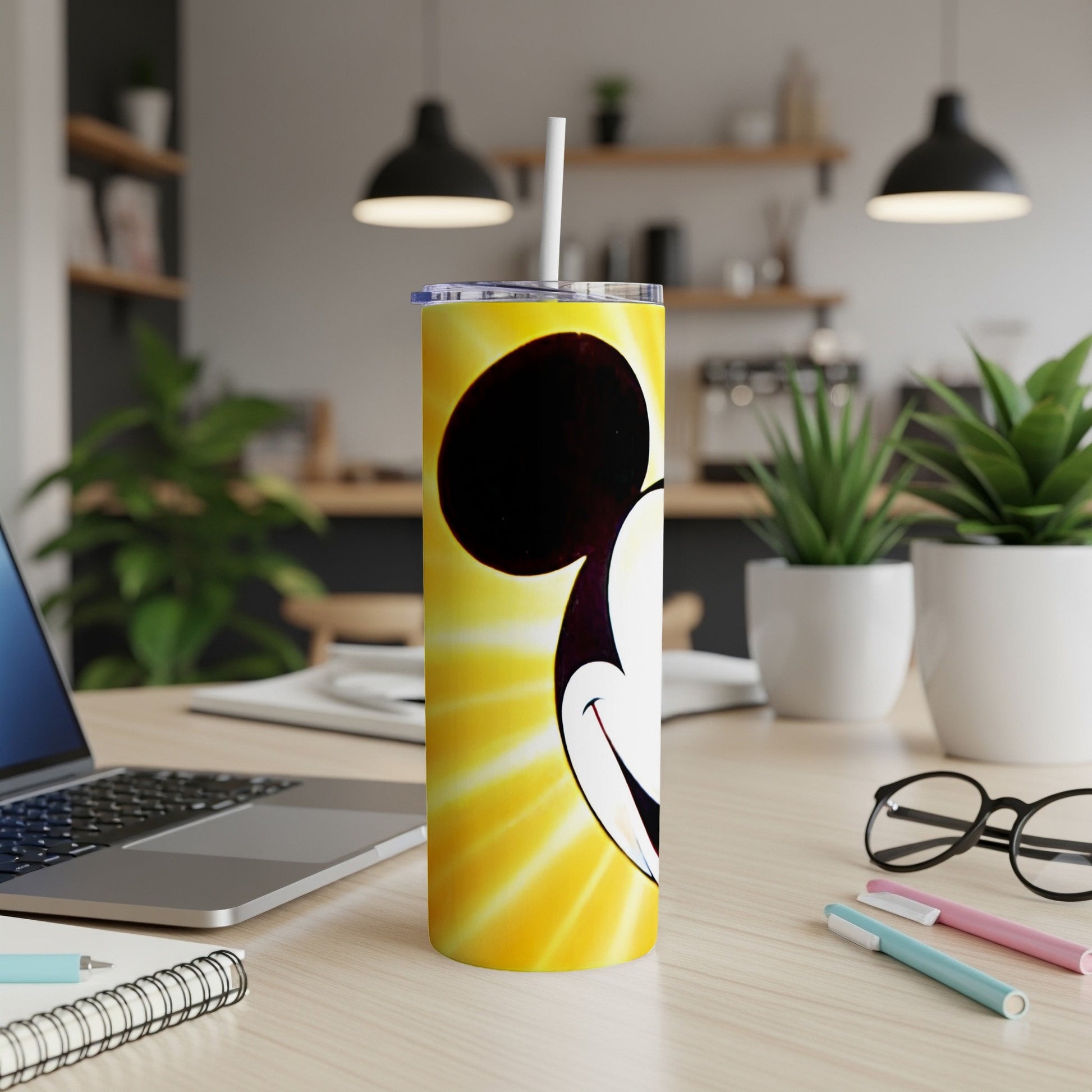 Mickey Mouse face on a yellow speckled tumbler with a straw.