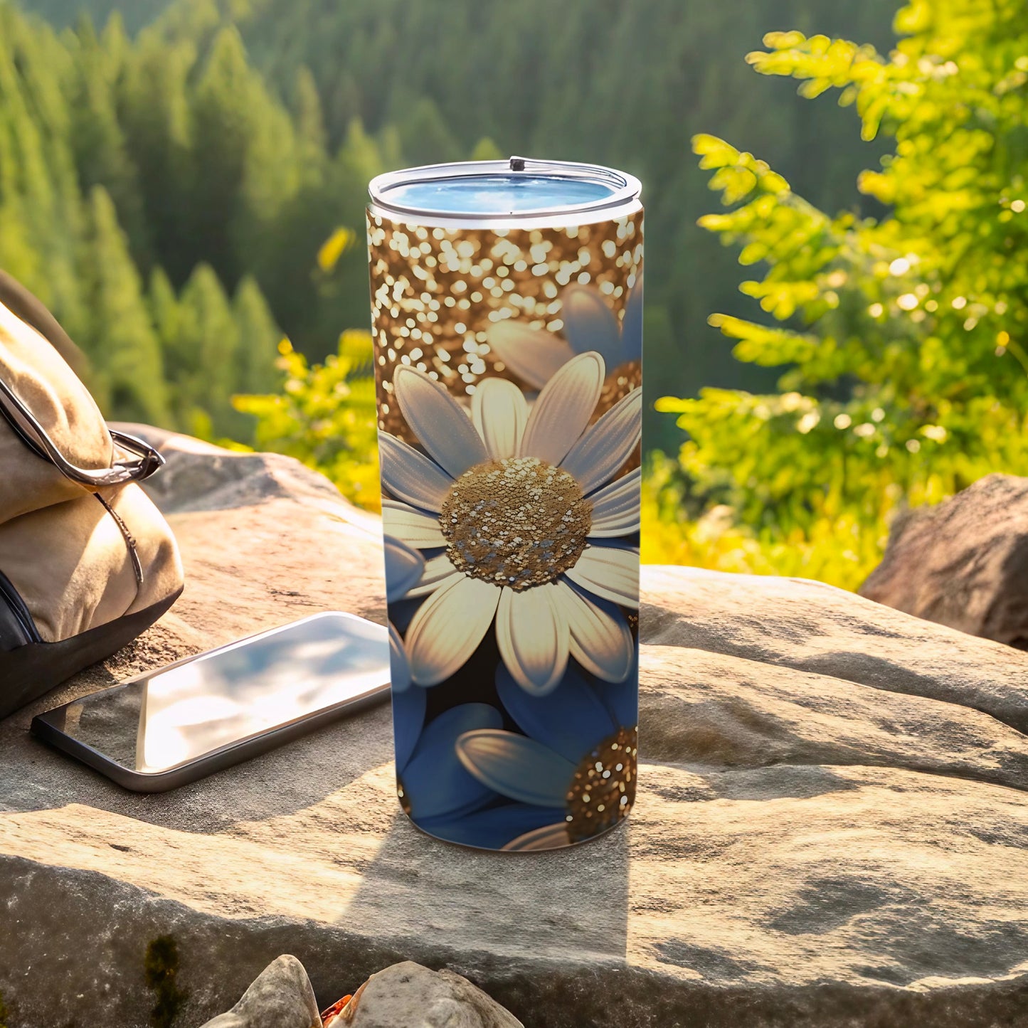 Tall tumbler with blue and gold daisy pattern on outdoor surface.