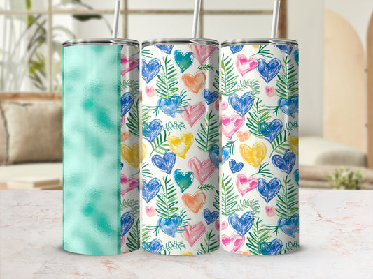 Three tumblers with heart and leaf designs and straw.
