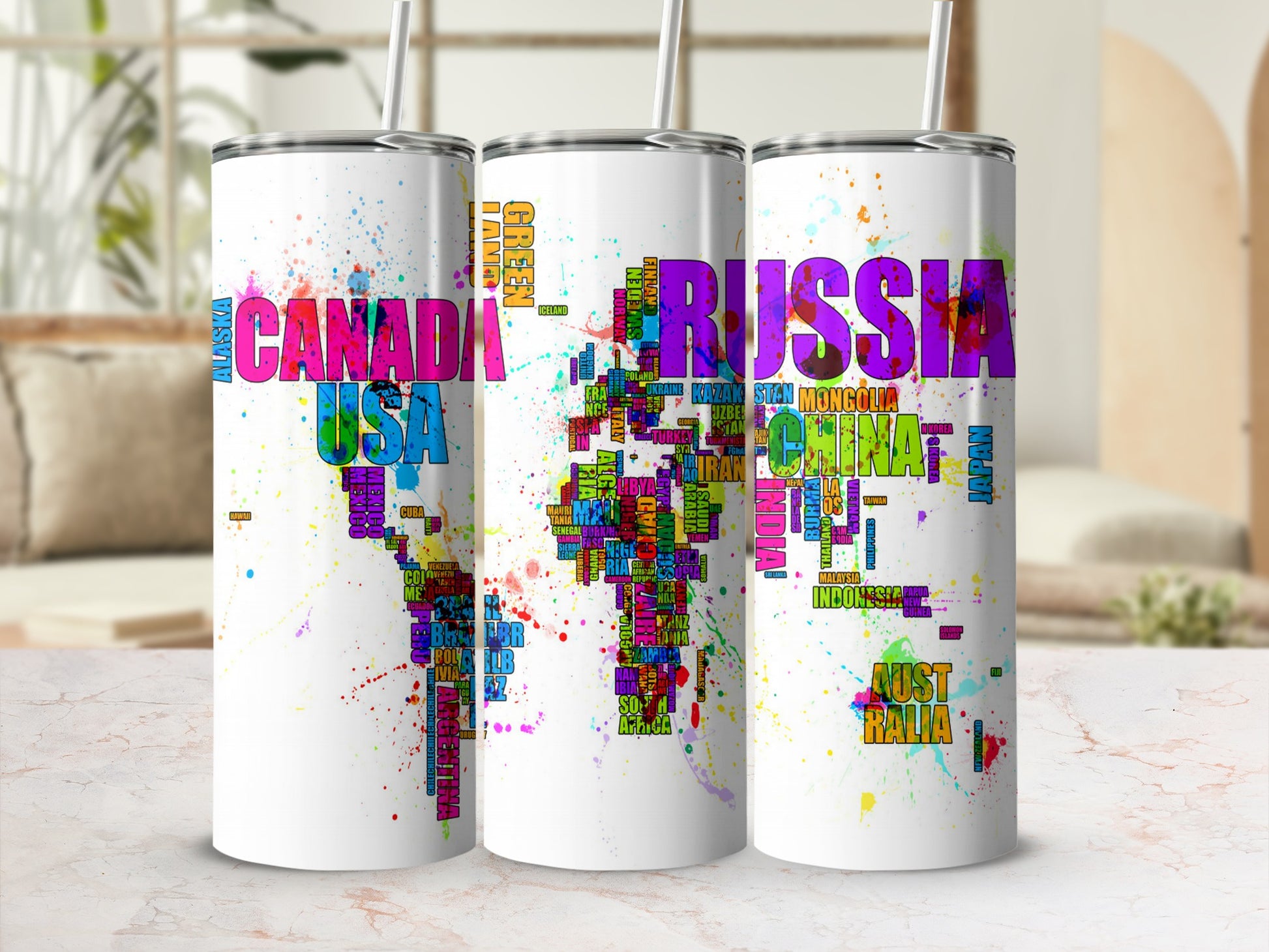 Three tumblers with world maps made of country names in vibrant colors and splatters.