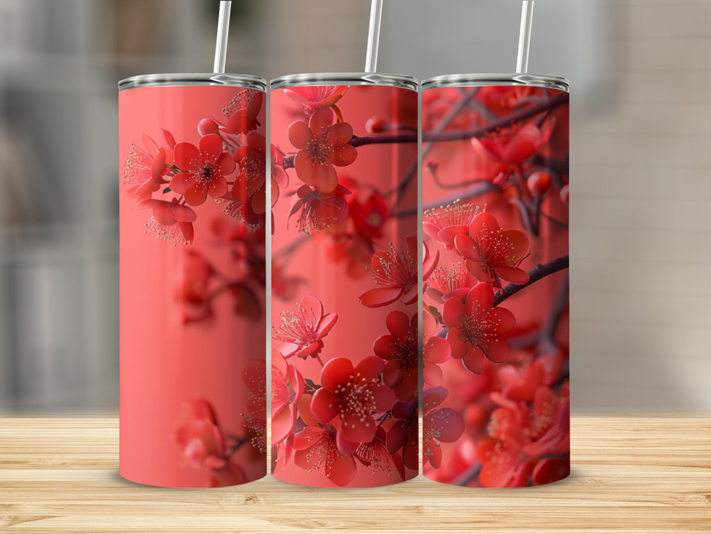 Three coral tumblers with blooming red cherry blossoms against a blurred background.