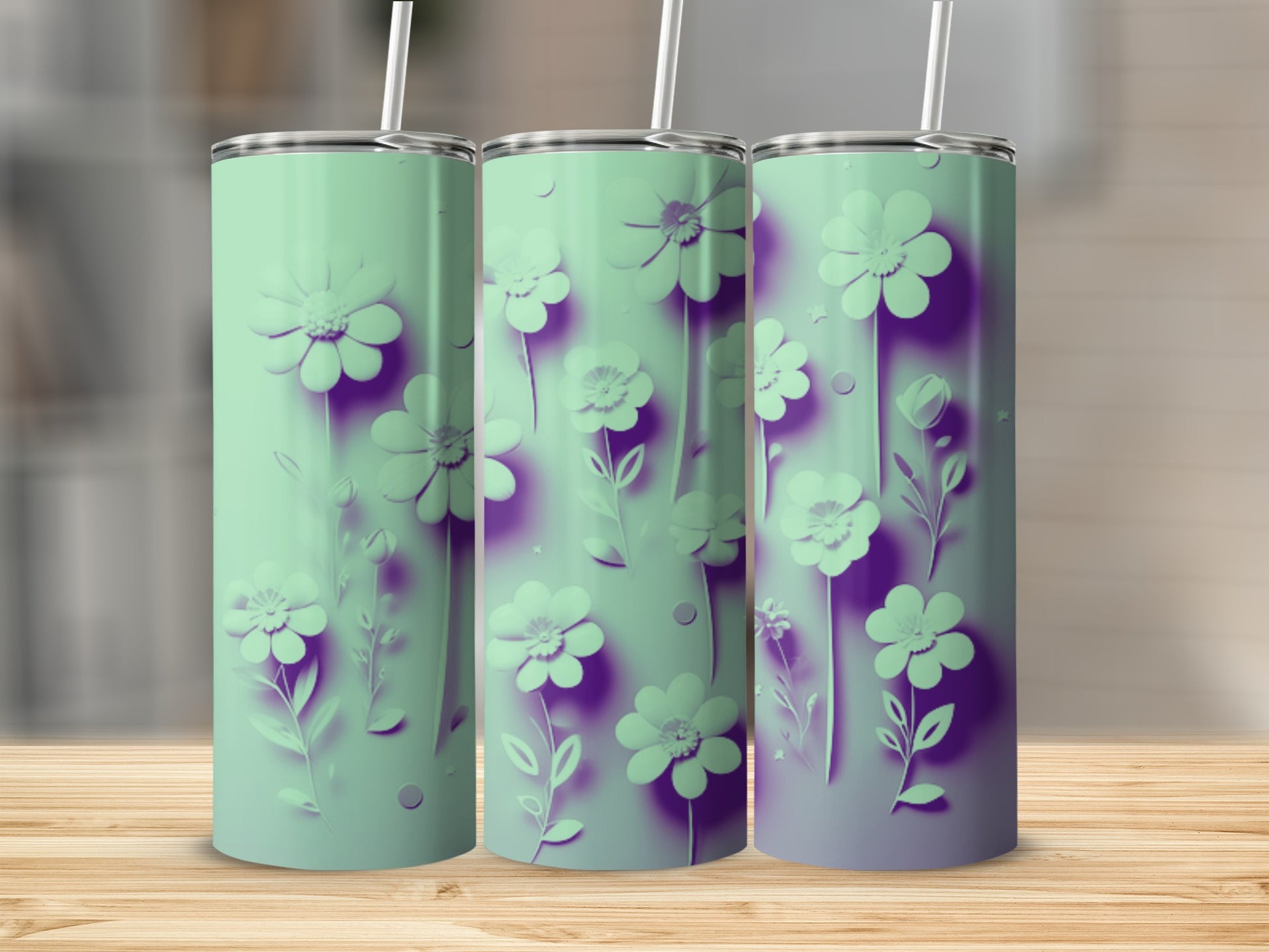Three mint green tumblers with purple floral designs displayed on a wooden surface.