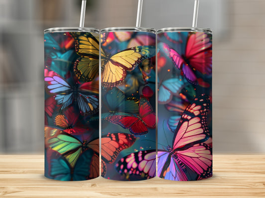 Three tumblers with colorful butterfly patterns on a wooden surface.