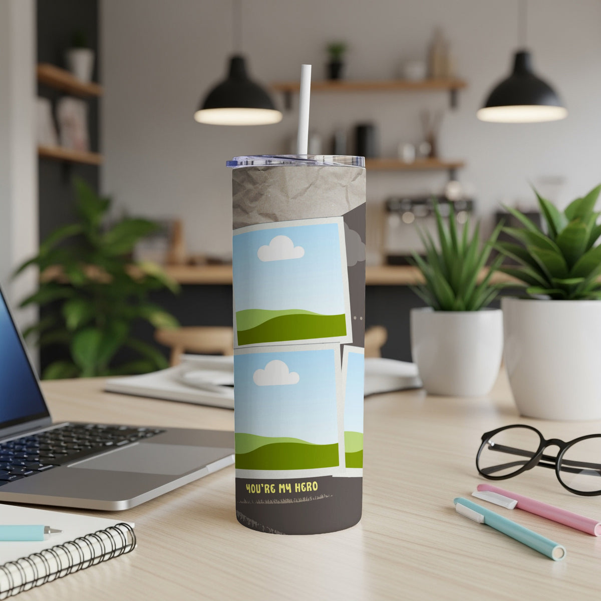 Tumbler with photo placeholders and "YOU'RE MY HERO" text on a desk.