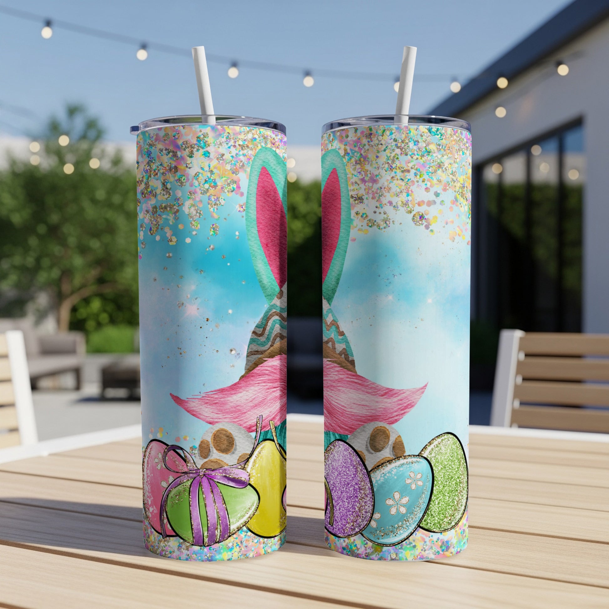 Two tumblers with Easter bunny and glitter designs sit on a table.