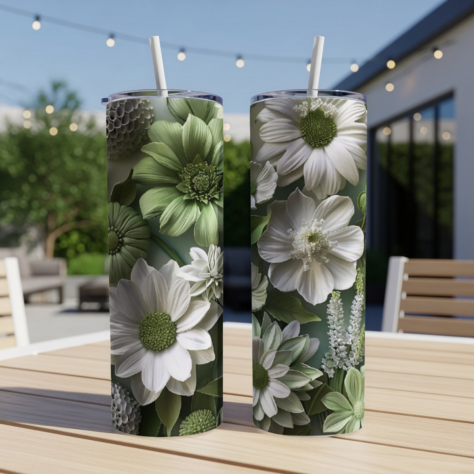 Two tall tumblers with green and white floral designs on a table.