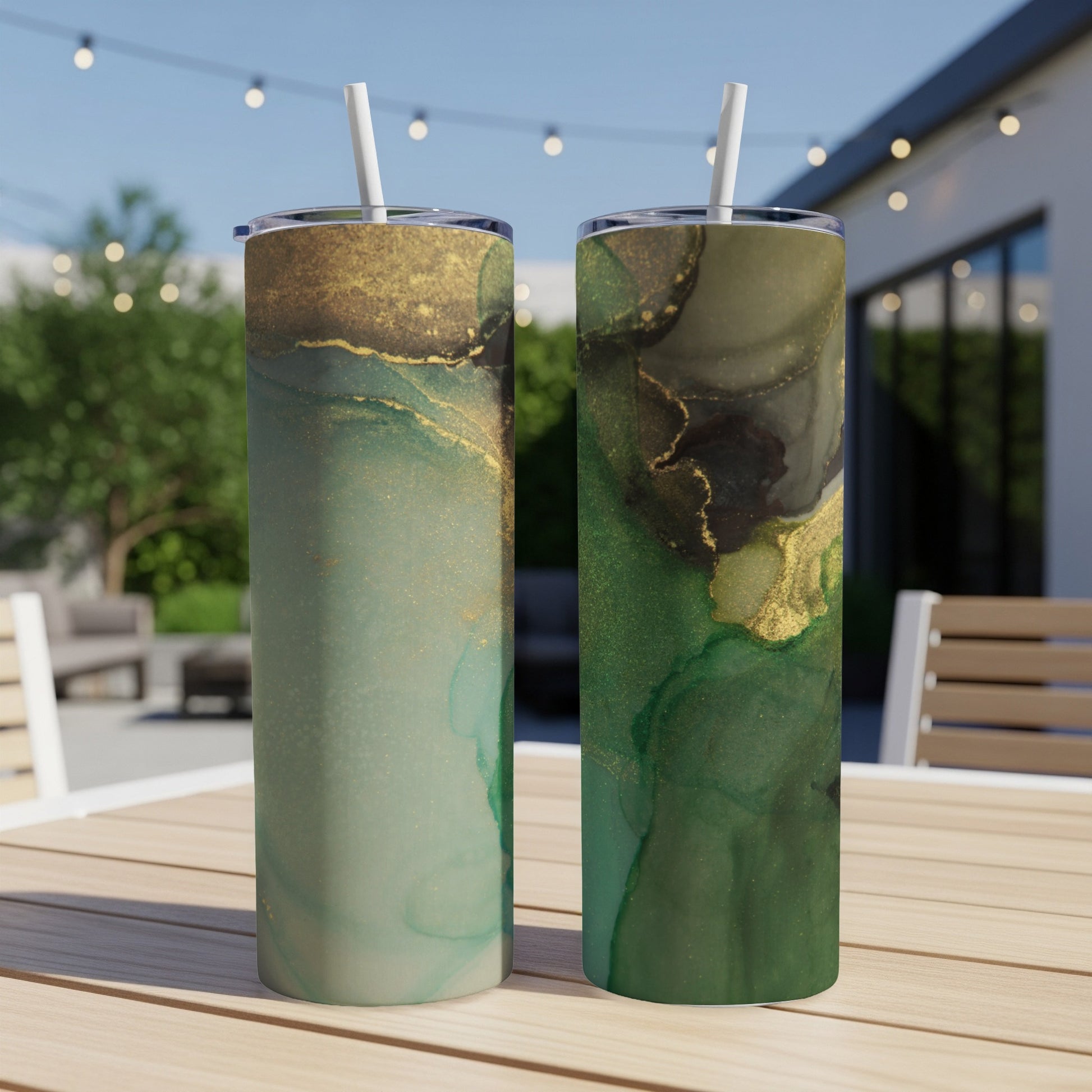 Two green and gold abstract pattern tumblers on a table.