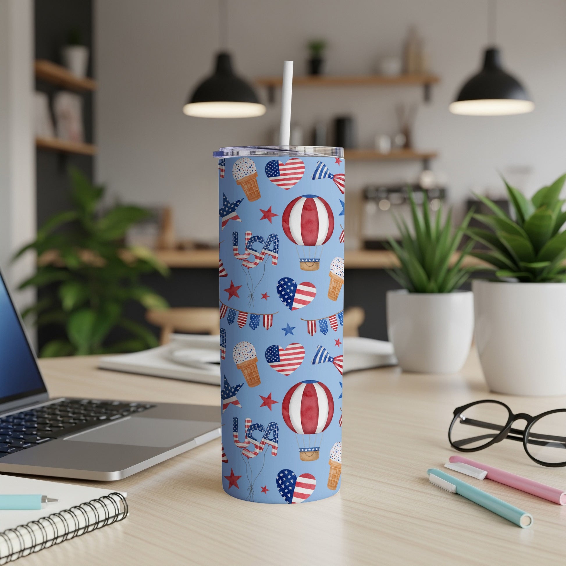 Blue tumbler with red, white, and blue patriotic pattern of hot air balloons and flags.