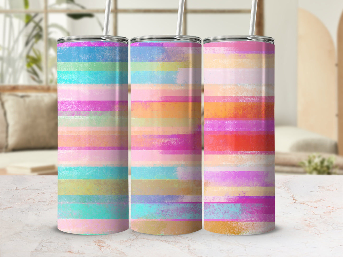 Three tumblers with pastel horizontal stripes and straws.