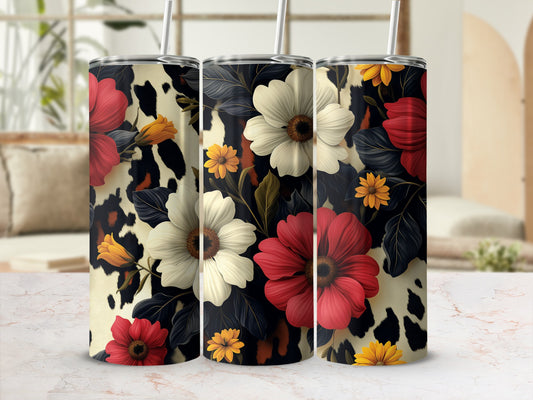 Three tumblers with floral and cow print designs on a table.