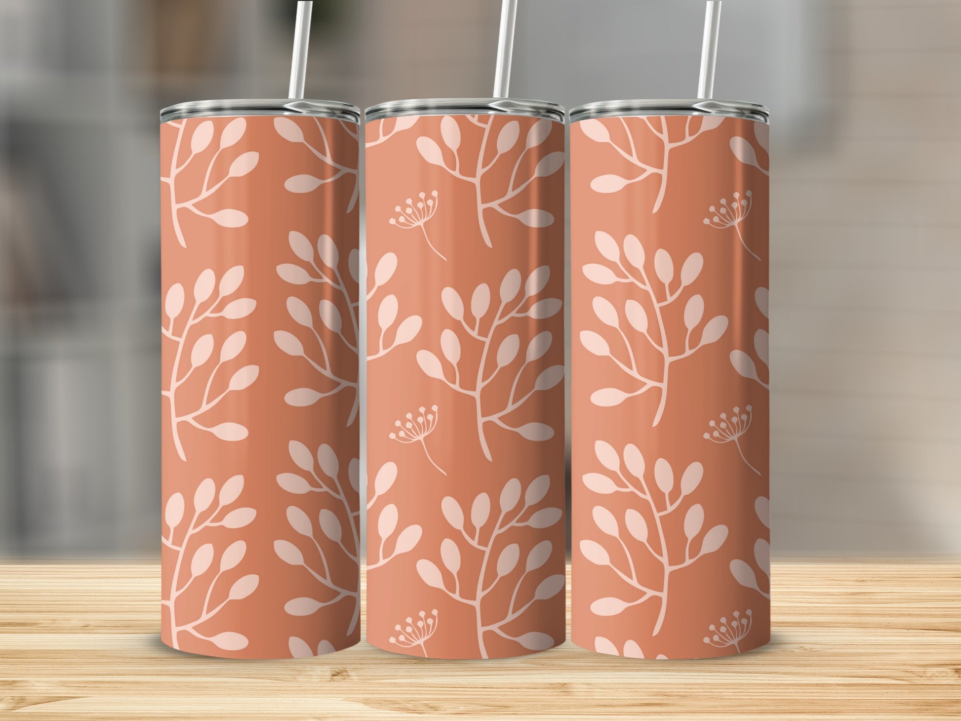 Three coral tumblers with a white floral branch pattern.