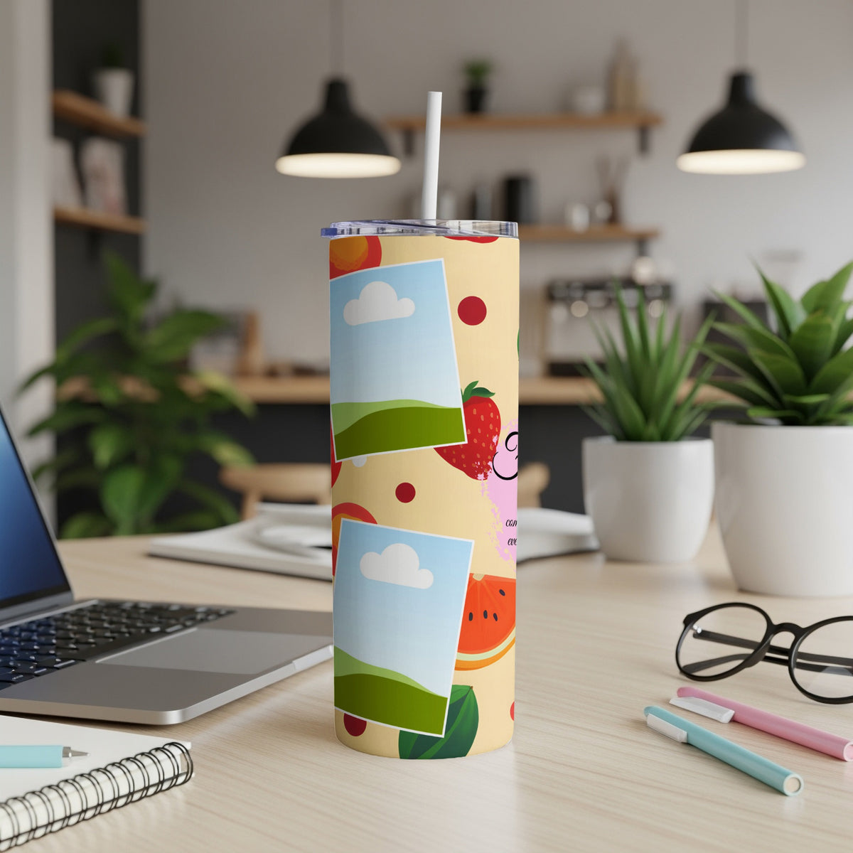 Yellow tumbler with fruit and photo frame patterns, straw inserted.