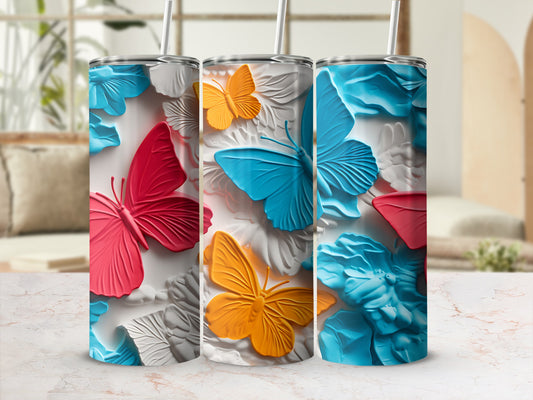Three colorful butterfly tumblers with floral accents displayed in a home setting.