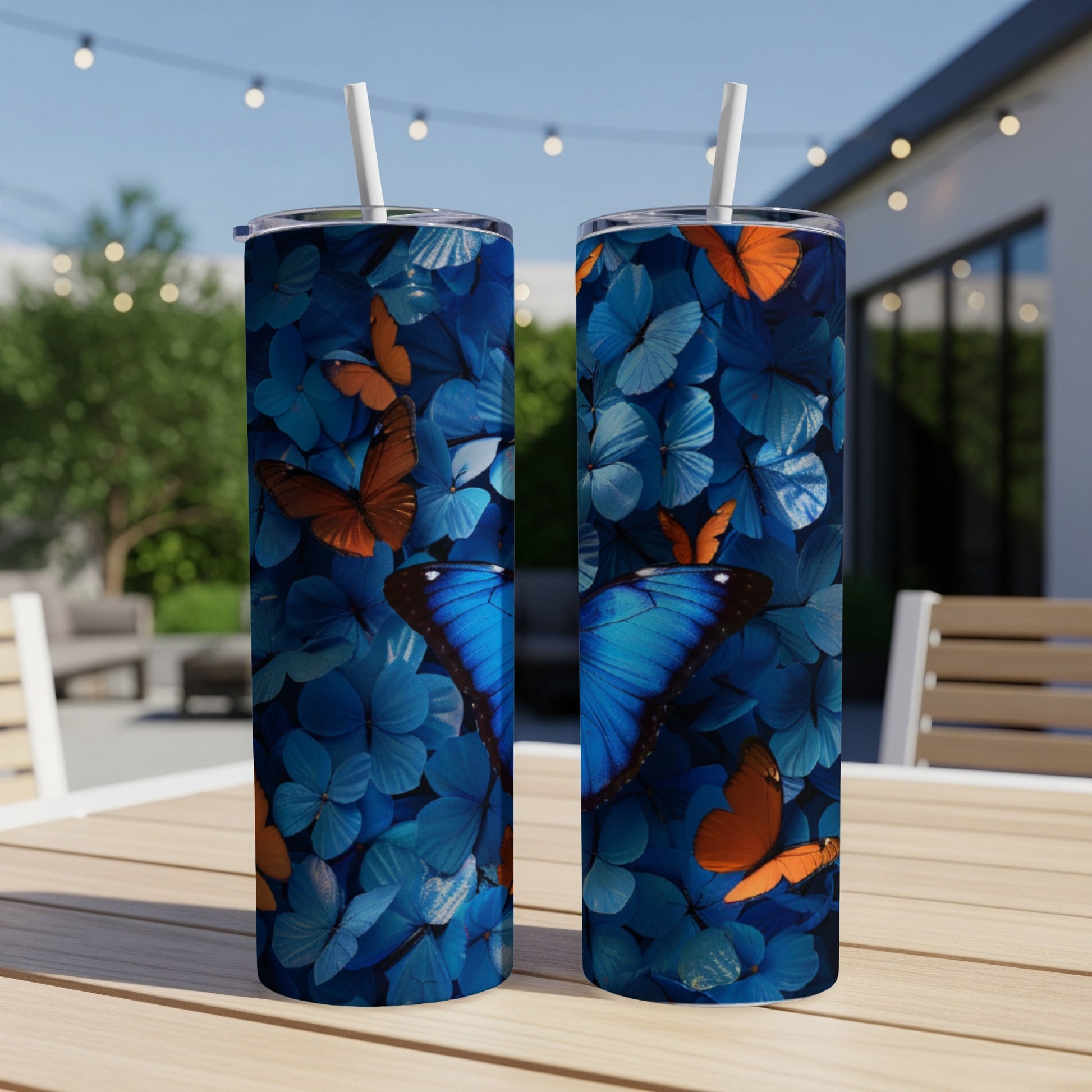 Two tumblers with blue and orange butterfly pattern on a table.