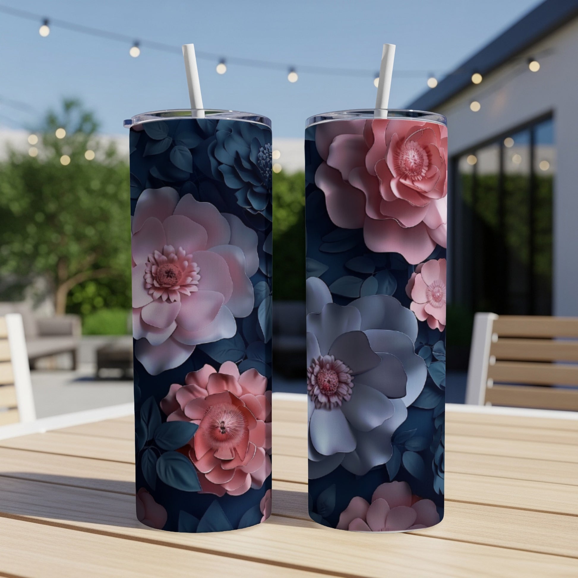 Two tall tumblers with pink and blue floral designs sit on a wooden table.