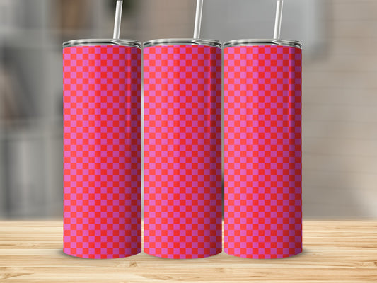 Three pink and red checkered skinny tumblers on a wooden surface.