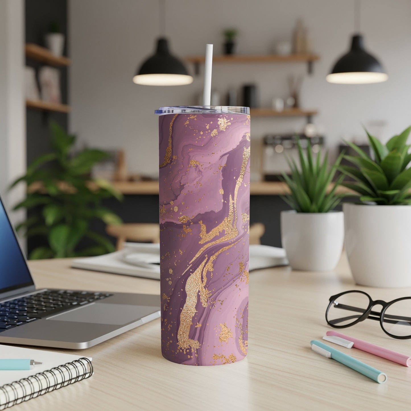 Purple and gold marble tumbler with a straw on a desk.