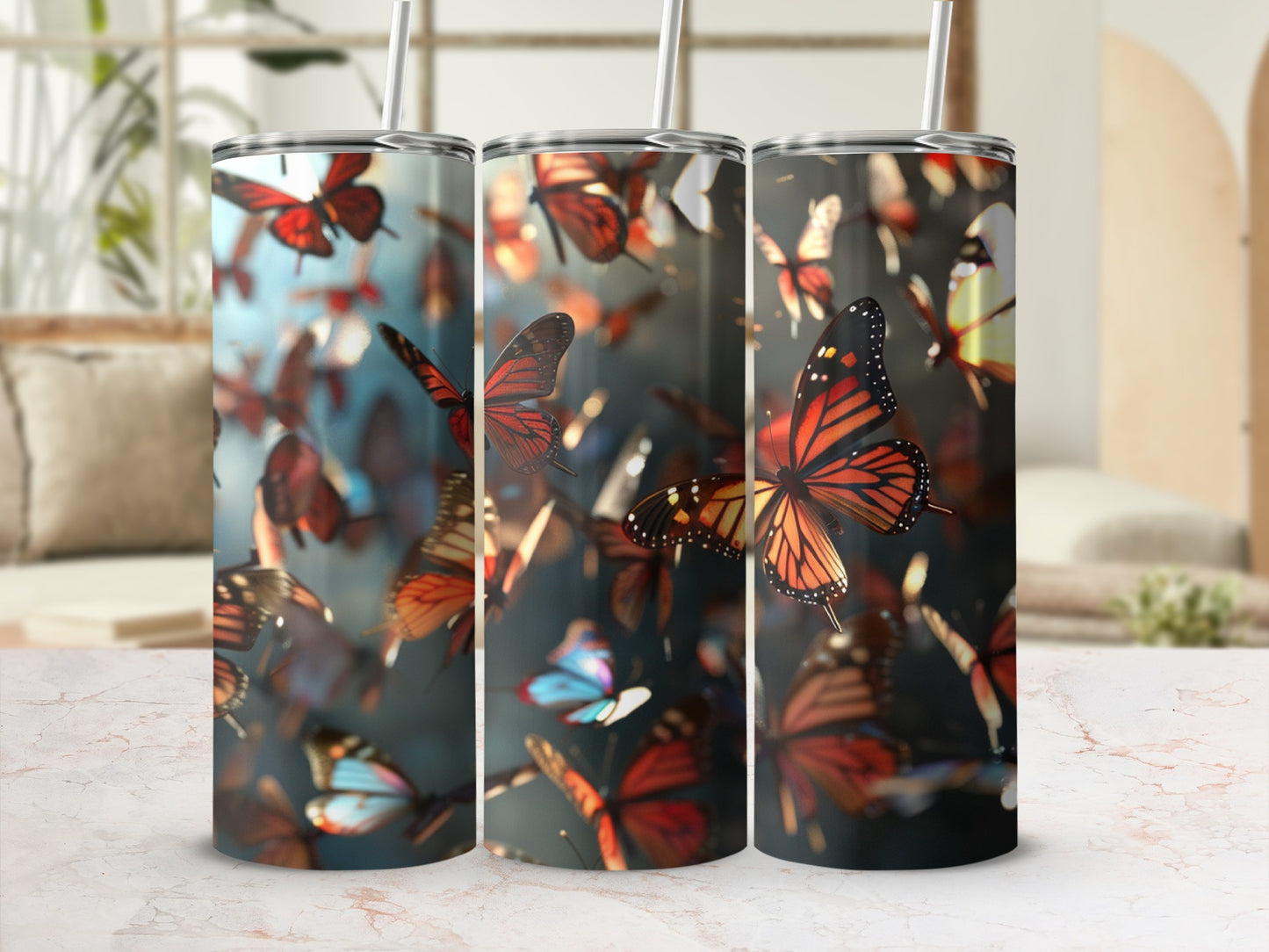 Three tumblers with a monarch butterfly pattern on a marble surface.