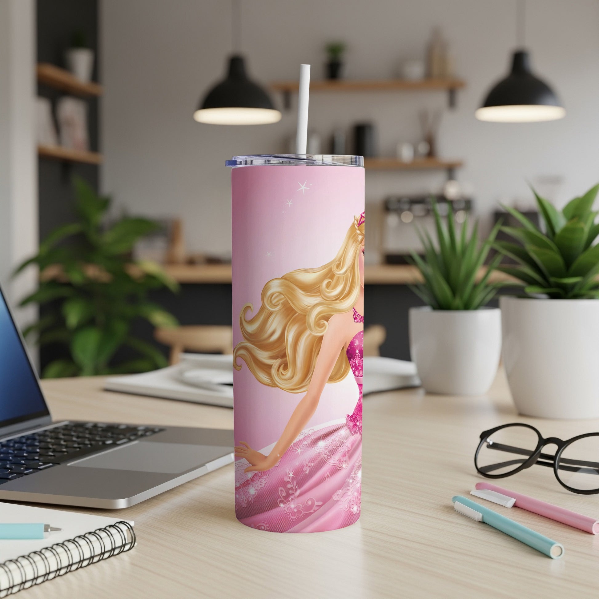 Pink Barbie tumbler with straw on a desk.