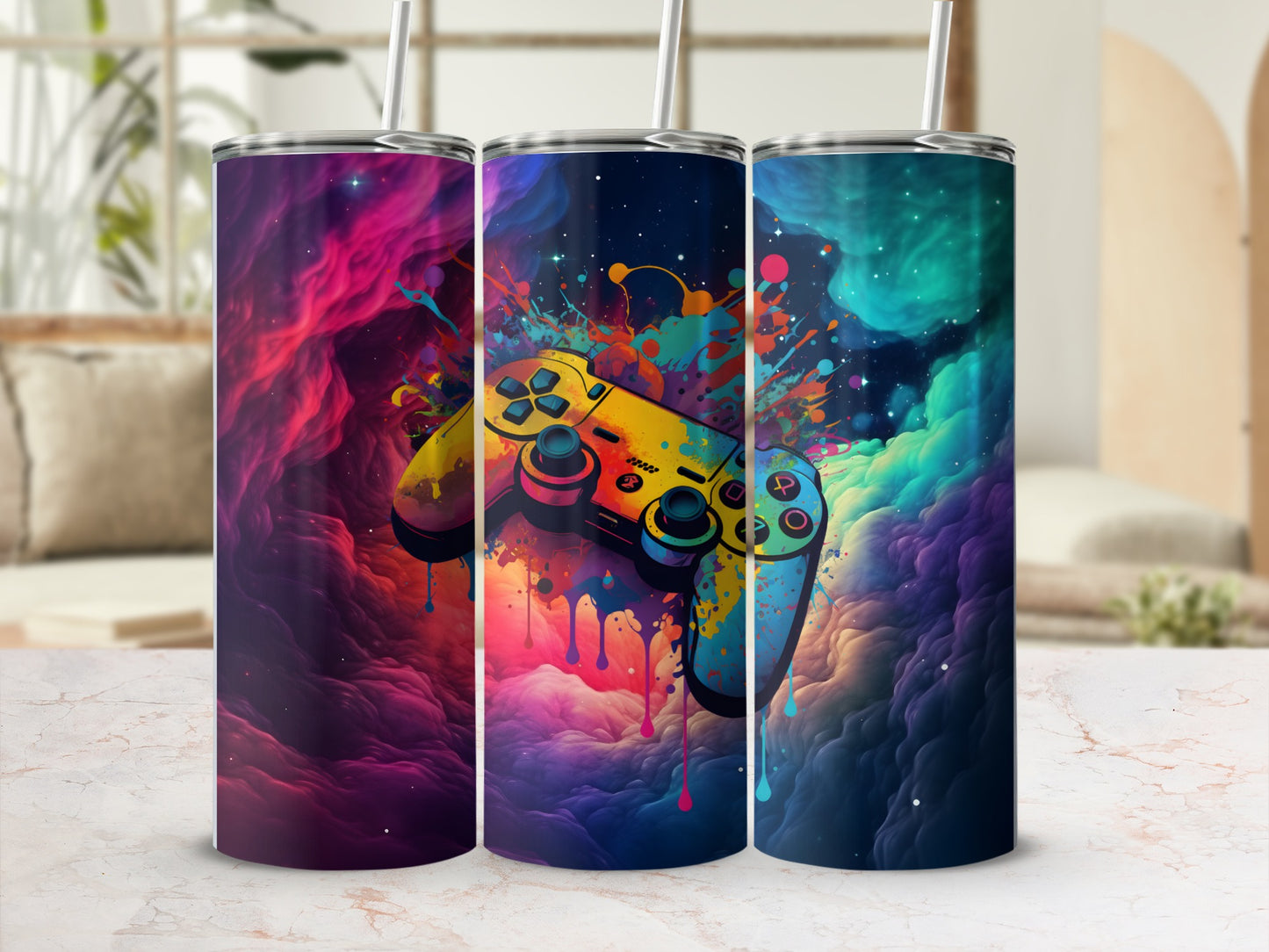 Three tumblers with colorful video game controller designs and nebula backgrounds.