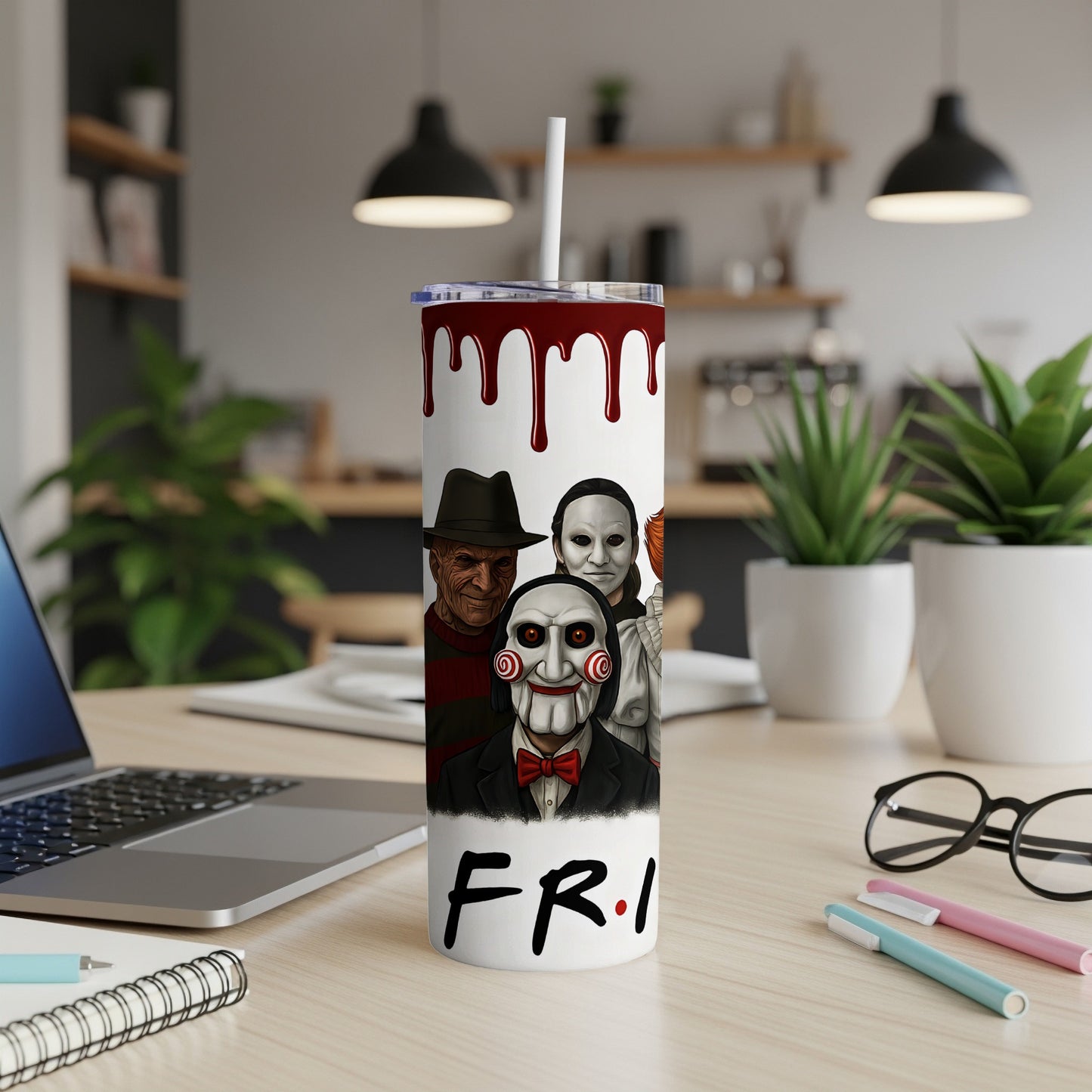 Tumbler with horror characters and "F.R.I." logo, set on a desk.