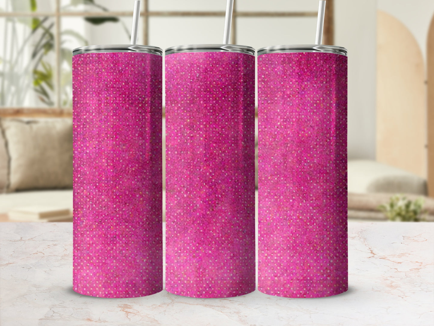 Three pink glitter tumblers with straws on a marble surface.