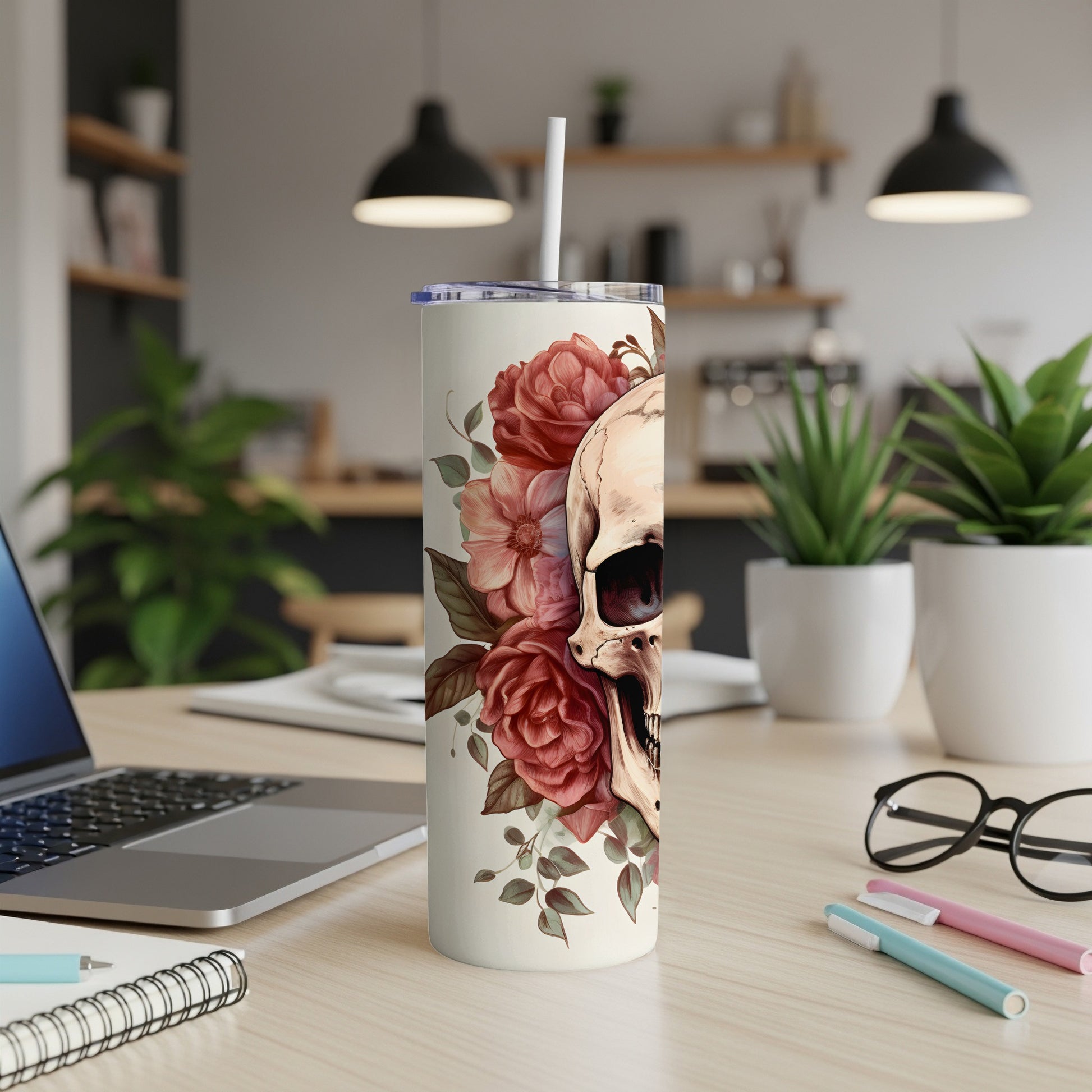 Cream tumbler with a skull and floral design and a white lid and straw.