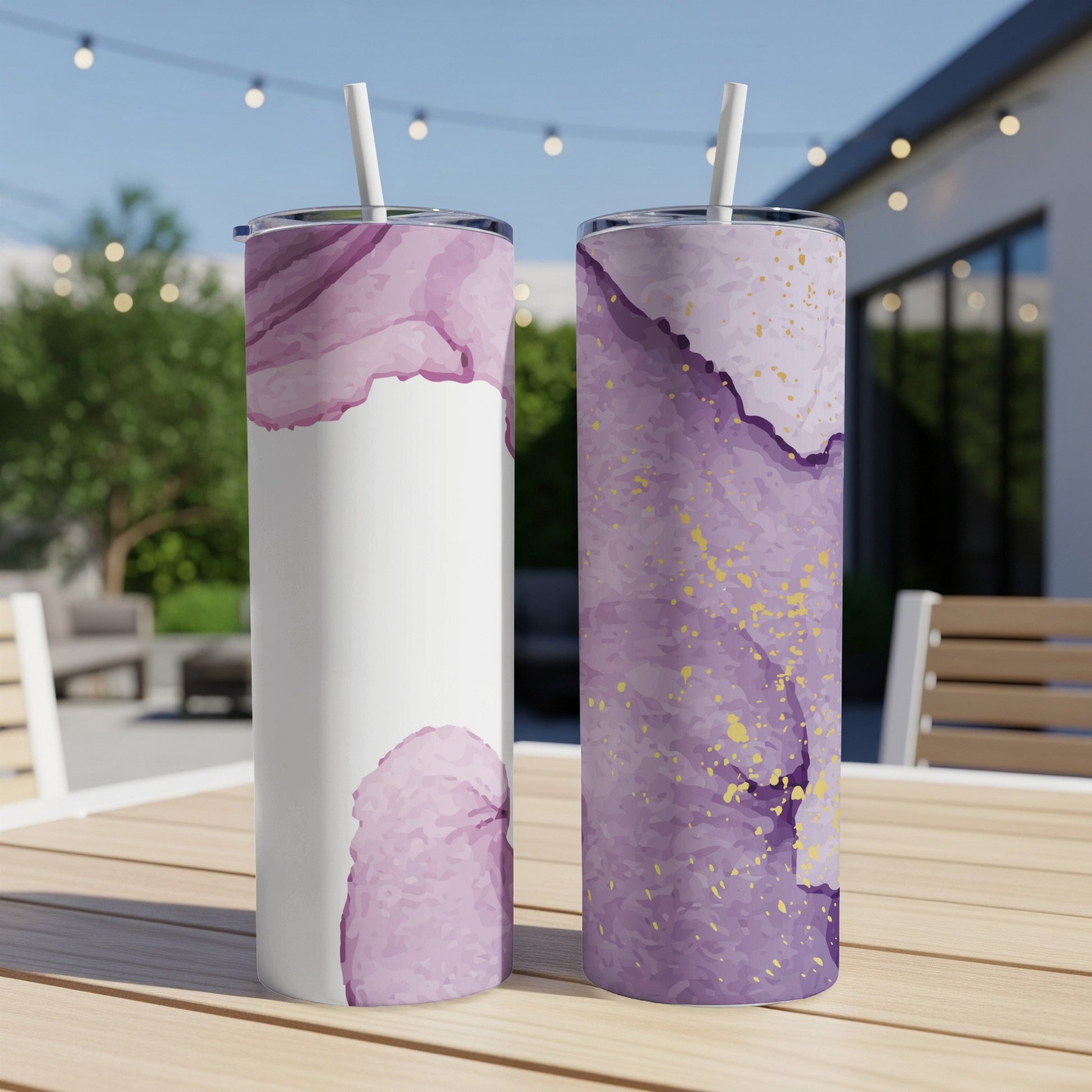 Two tumblers with purple watercolor and gold flake designs on a table.