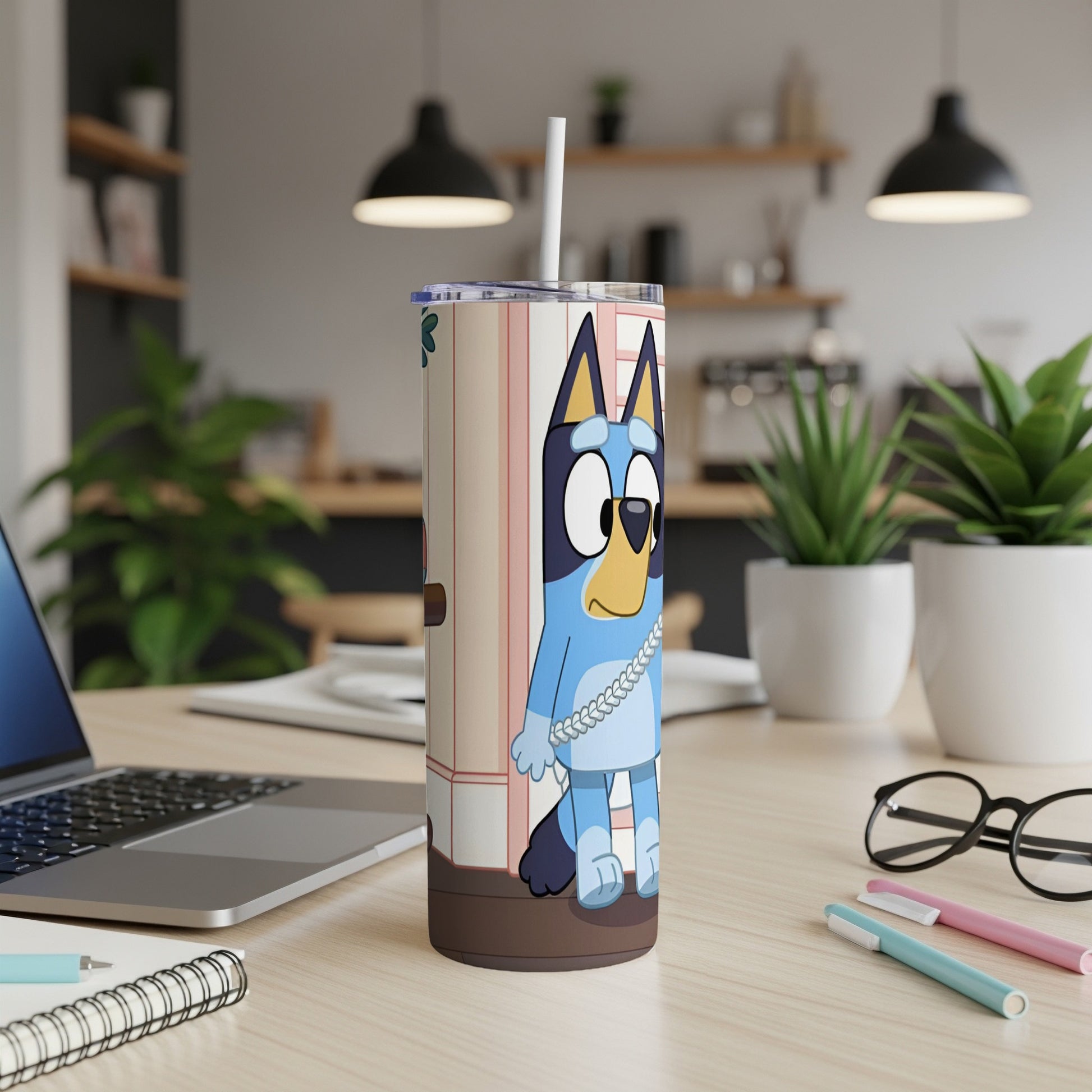 Bluey character on a white tumbler with a straw, on a desk.