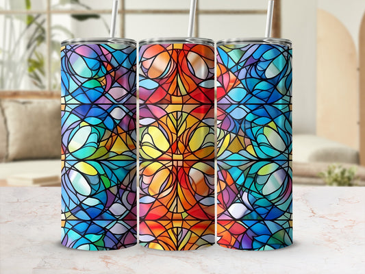 Three colorful stained glass pattern tumblers with straws on a marble surface.