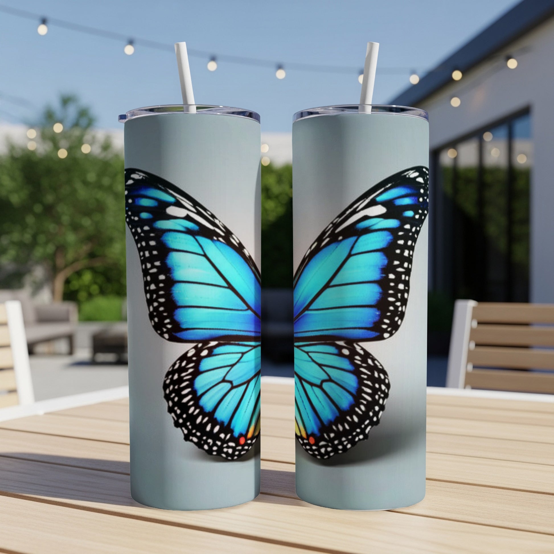 Two blue butterfly wing design tumblers on a table.