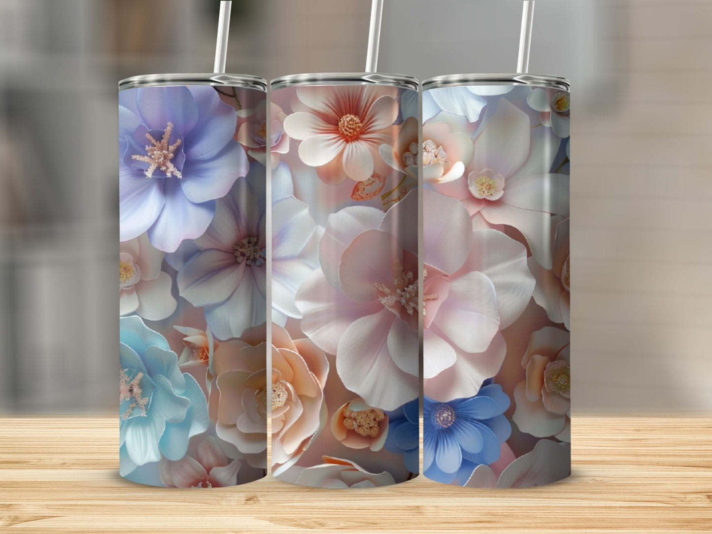 Three tumblers with floral patterns in pastel colors arranged on a wooden surface.