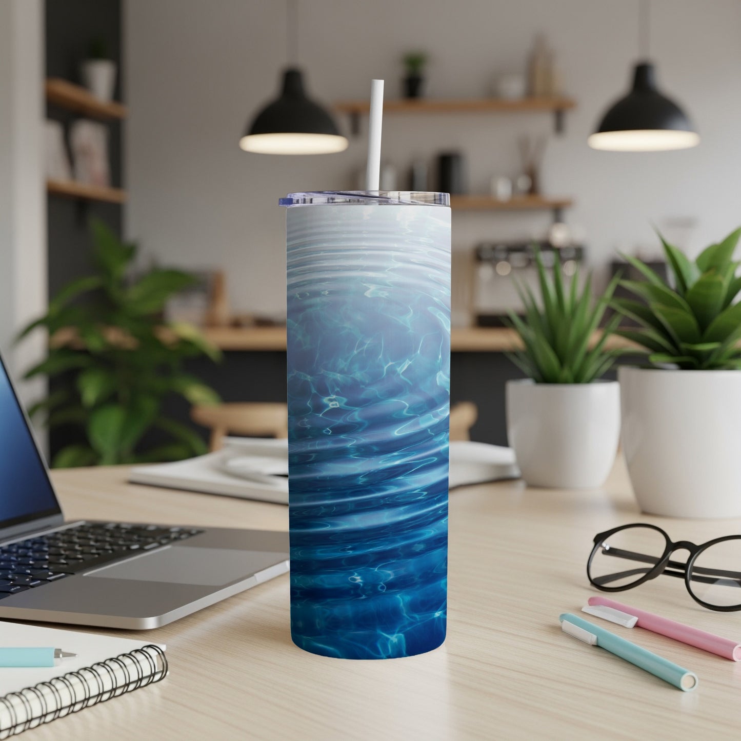 Blue water ripple pattern on a tall, cylindrical tumbler with a straw.