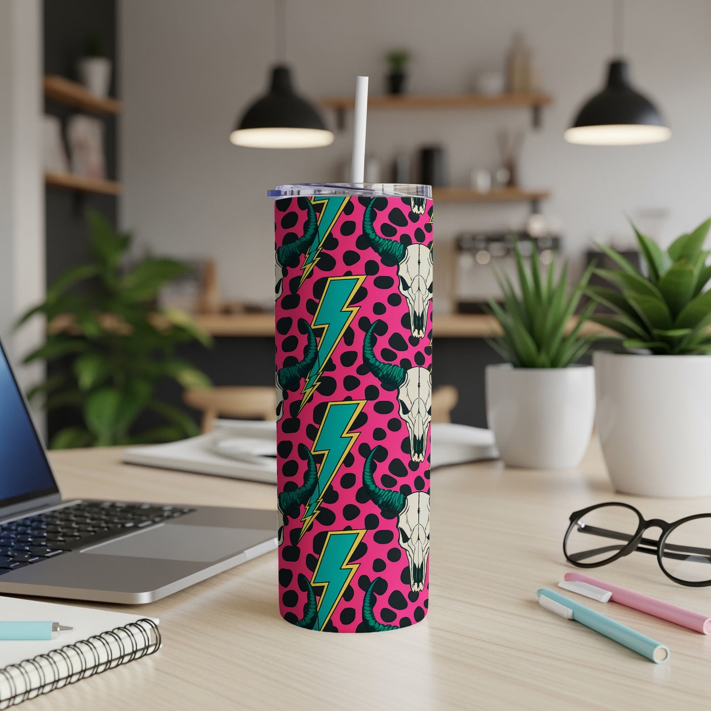 Pink tumbler with teal lightning bolts and cow skull pattern.
