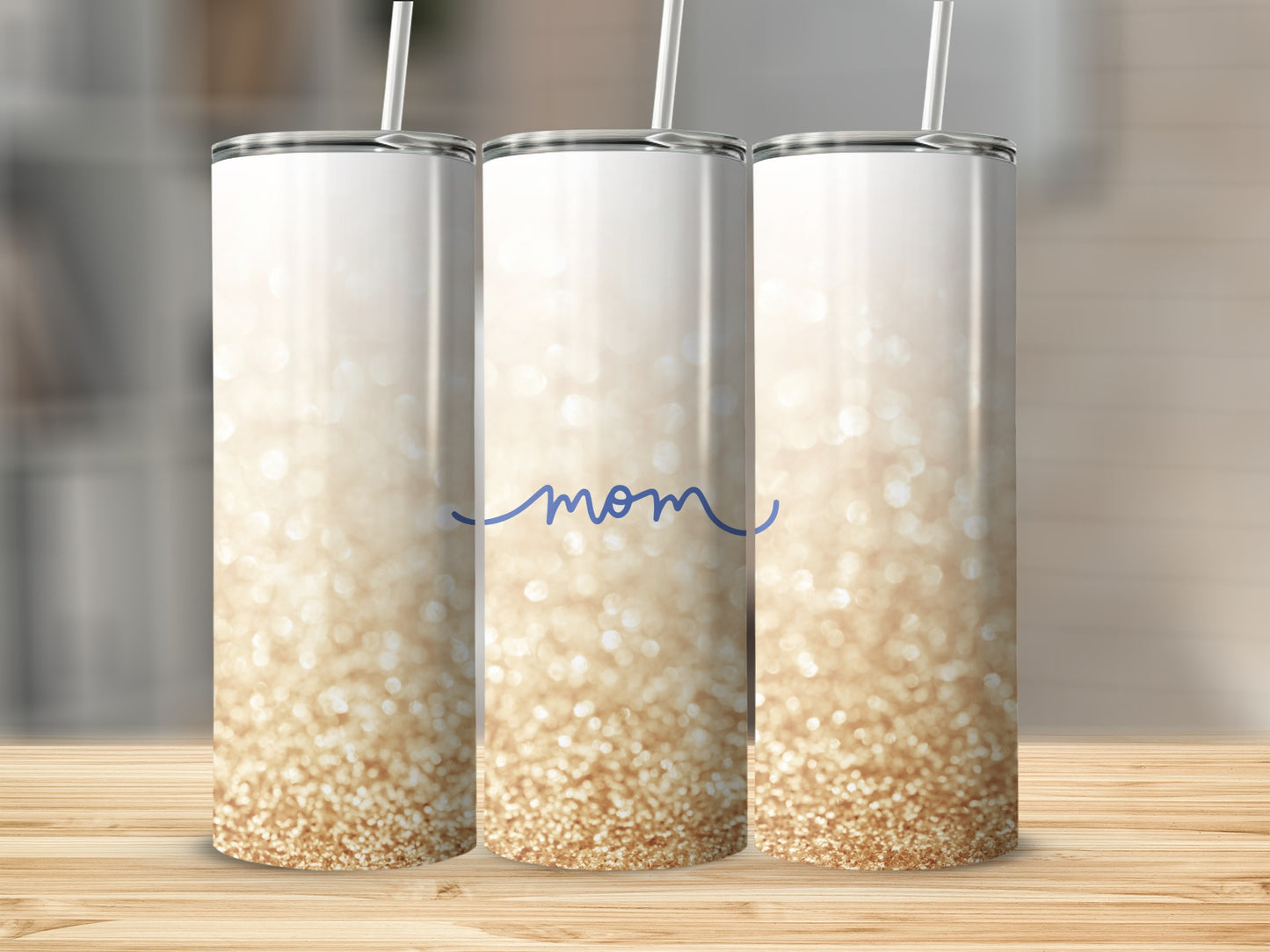 White tumbler with "Mom" in blue script and gold glitter ombre.