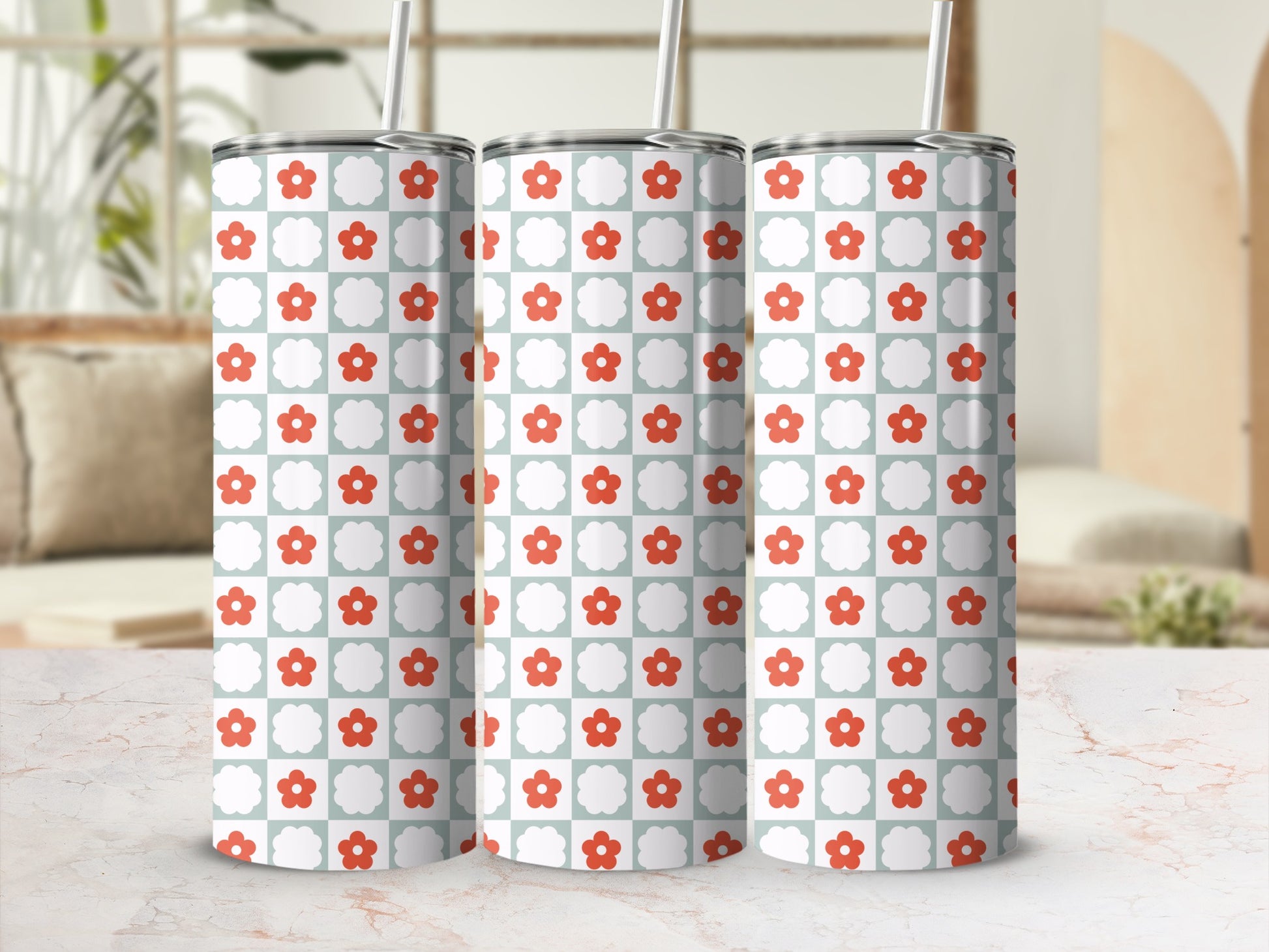 Three patterned tumblers with red flowers on a light blue checkered background.