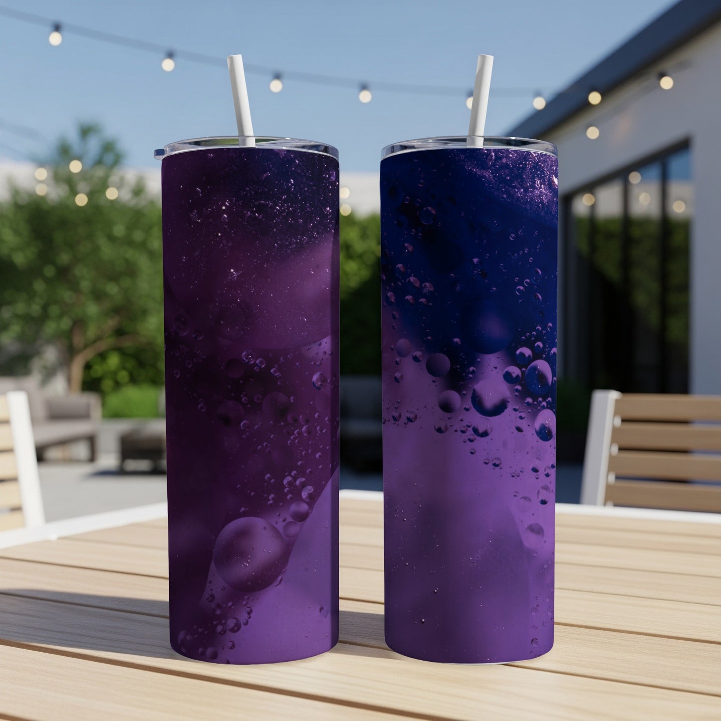 Two purple tumblers with oil and water bubble designs and straws.
