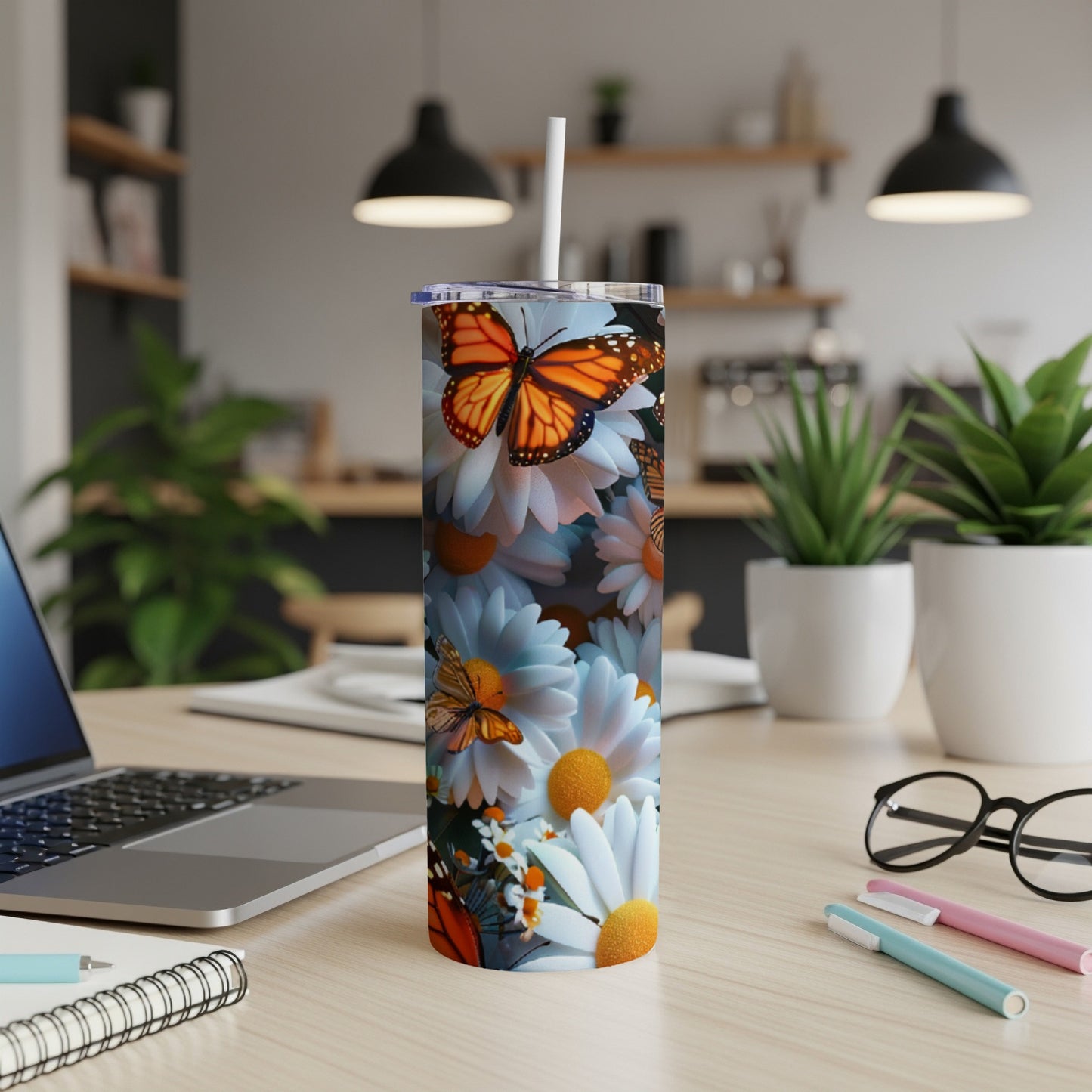 White daisy and butterfly pattern on a skinny tumbler with a white straw.