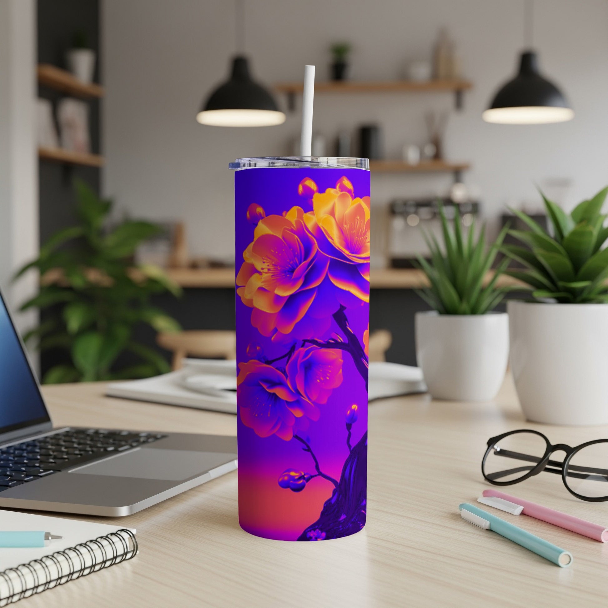Purple and orange floral art on a skinny tumbler with a straw.