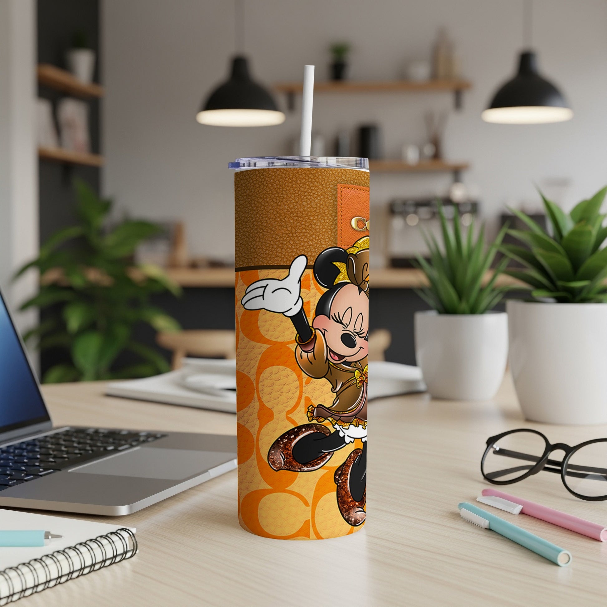 Minnie Mouse tumbler with brown leather accents and orange Coach-like pattern.