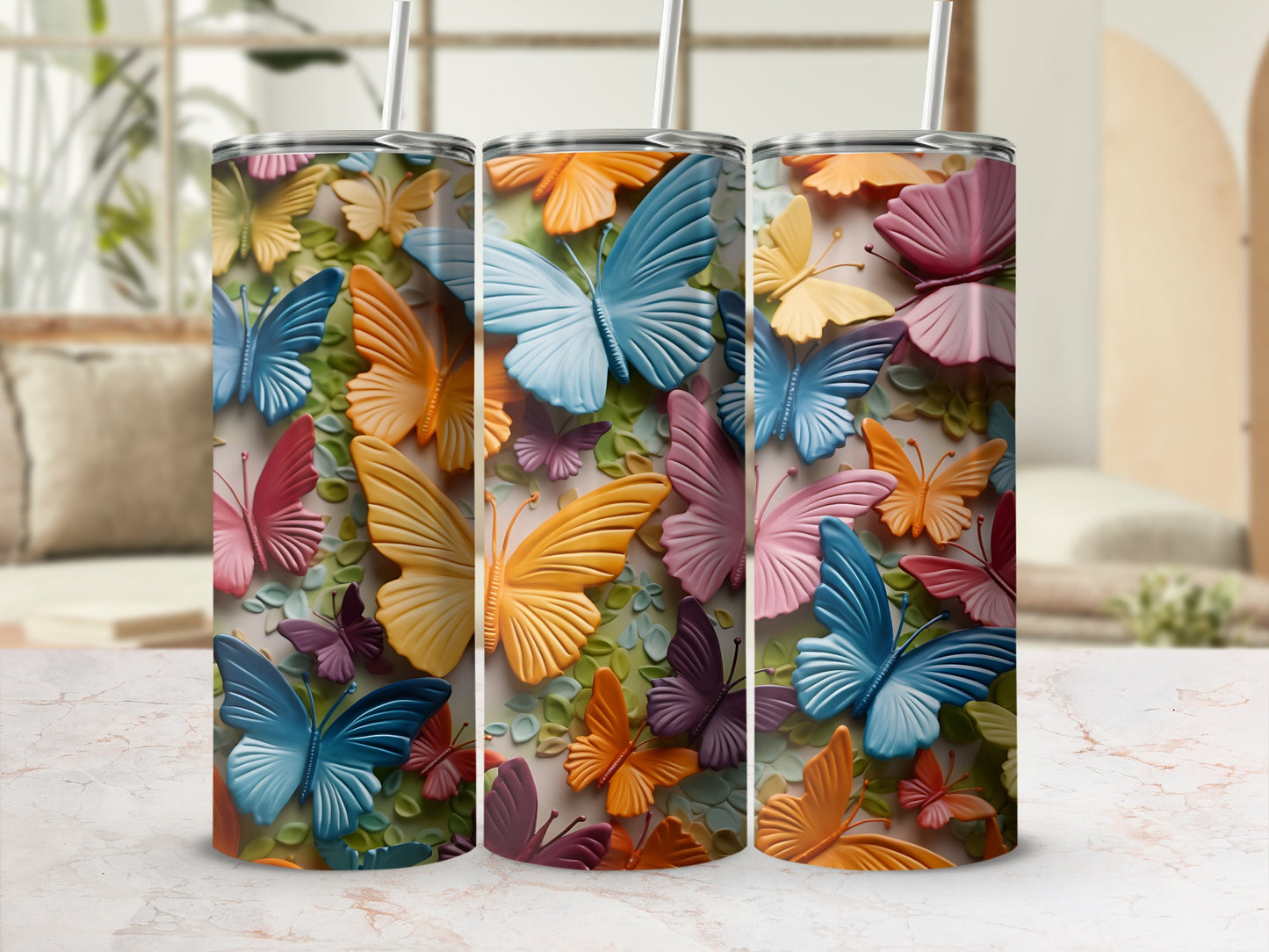 Three tumblers with colorful butterfly designs in a home setting.