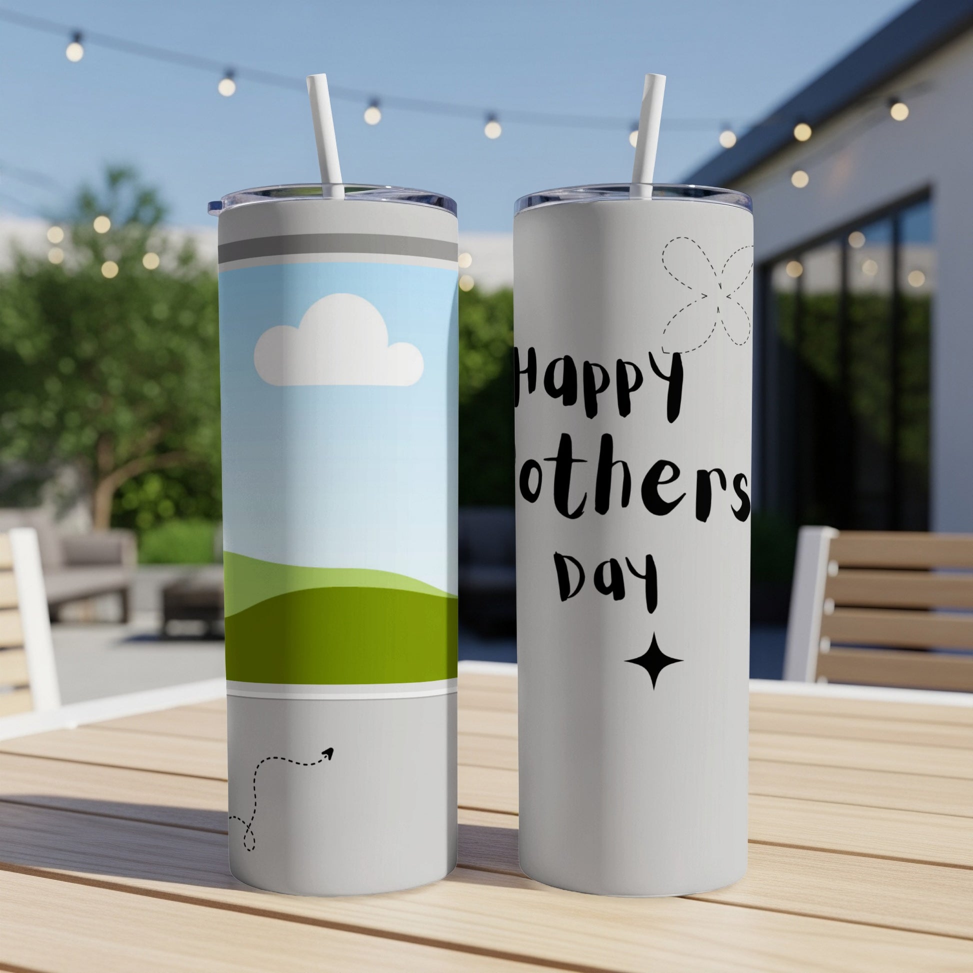 Two tumblers on a table, one with clouds and landscape, the other with "Happy Mother's Day".