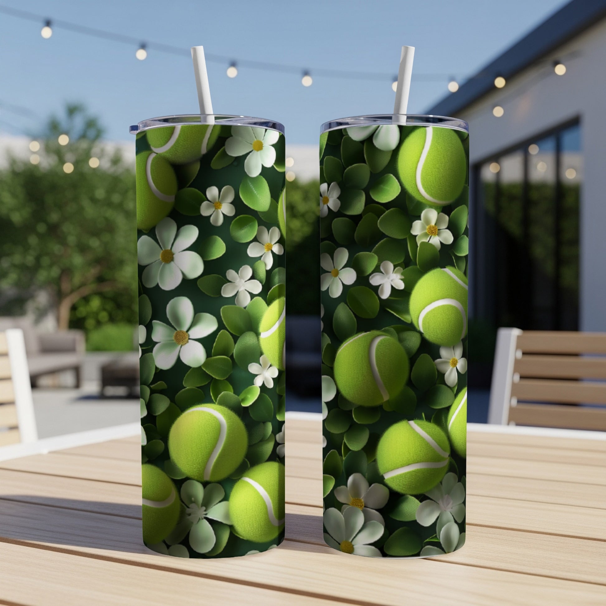 Two tennis ball themed tumblers with a floral pattern on a wooden table.
