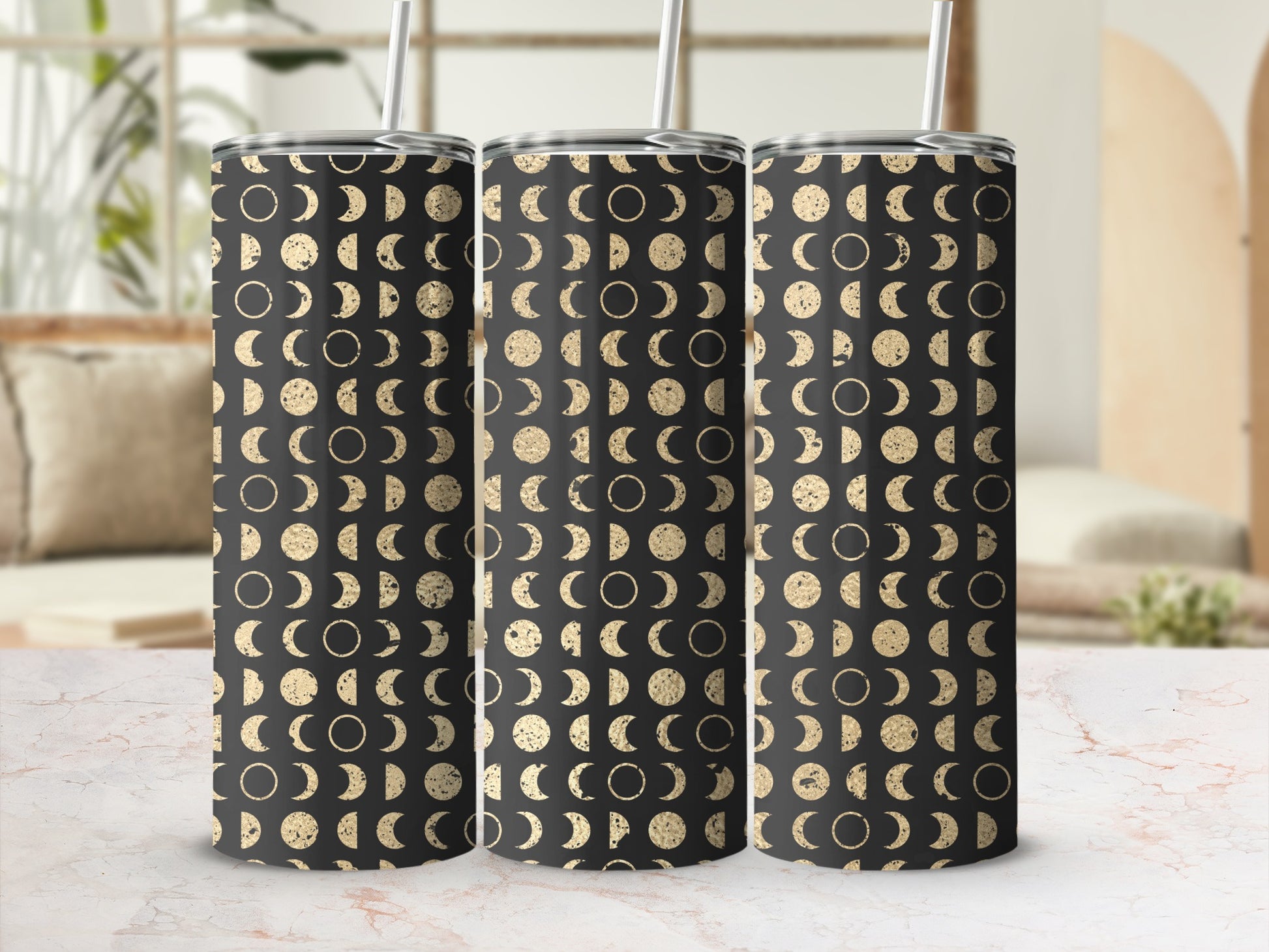 Three tumblers with a black and gold moon phase pattern, each with a white straw.