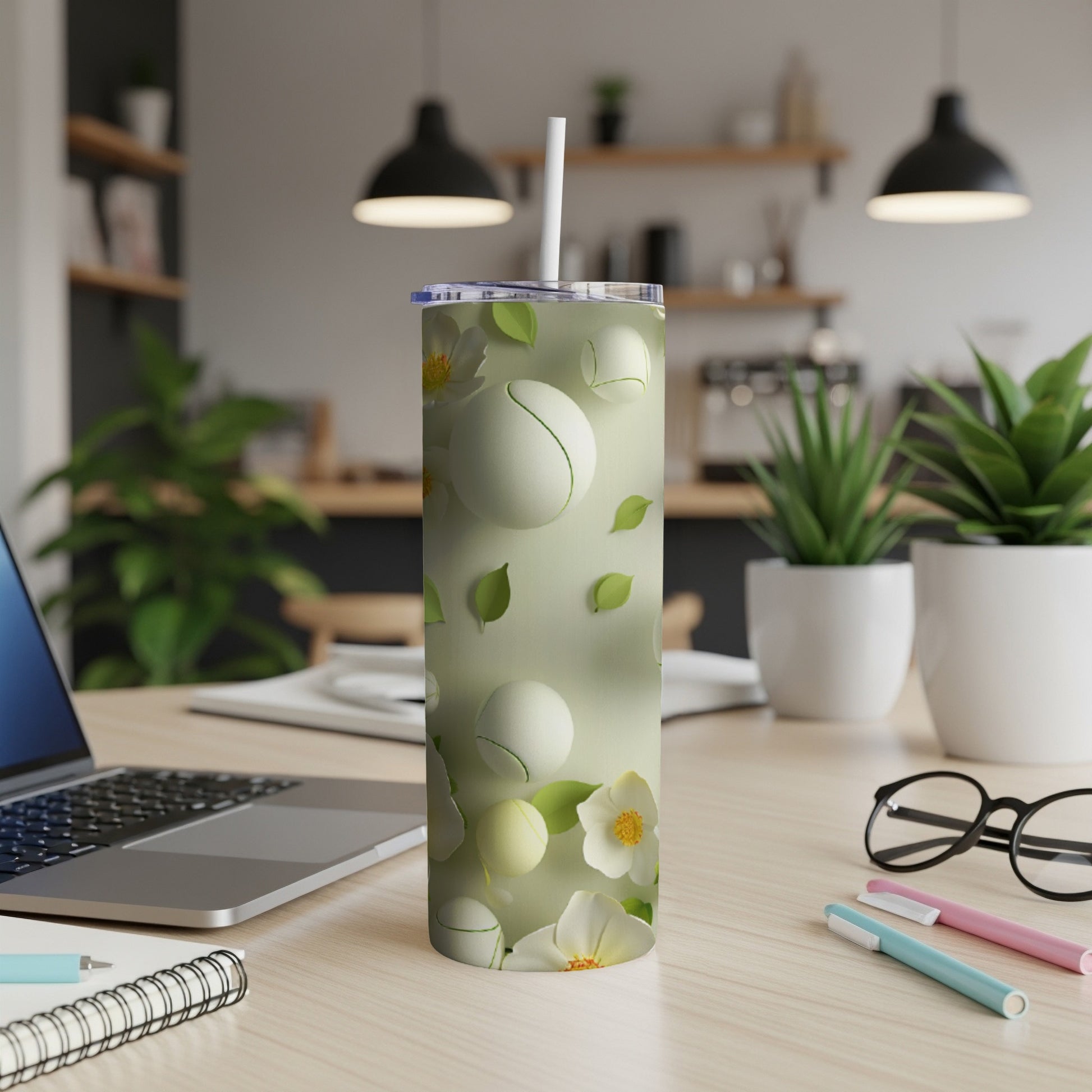 Green tumbler with white floral and tennis ball pattern.