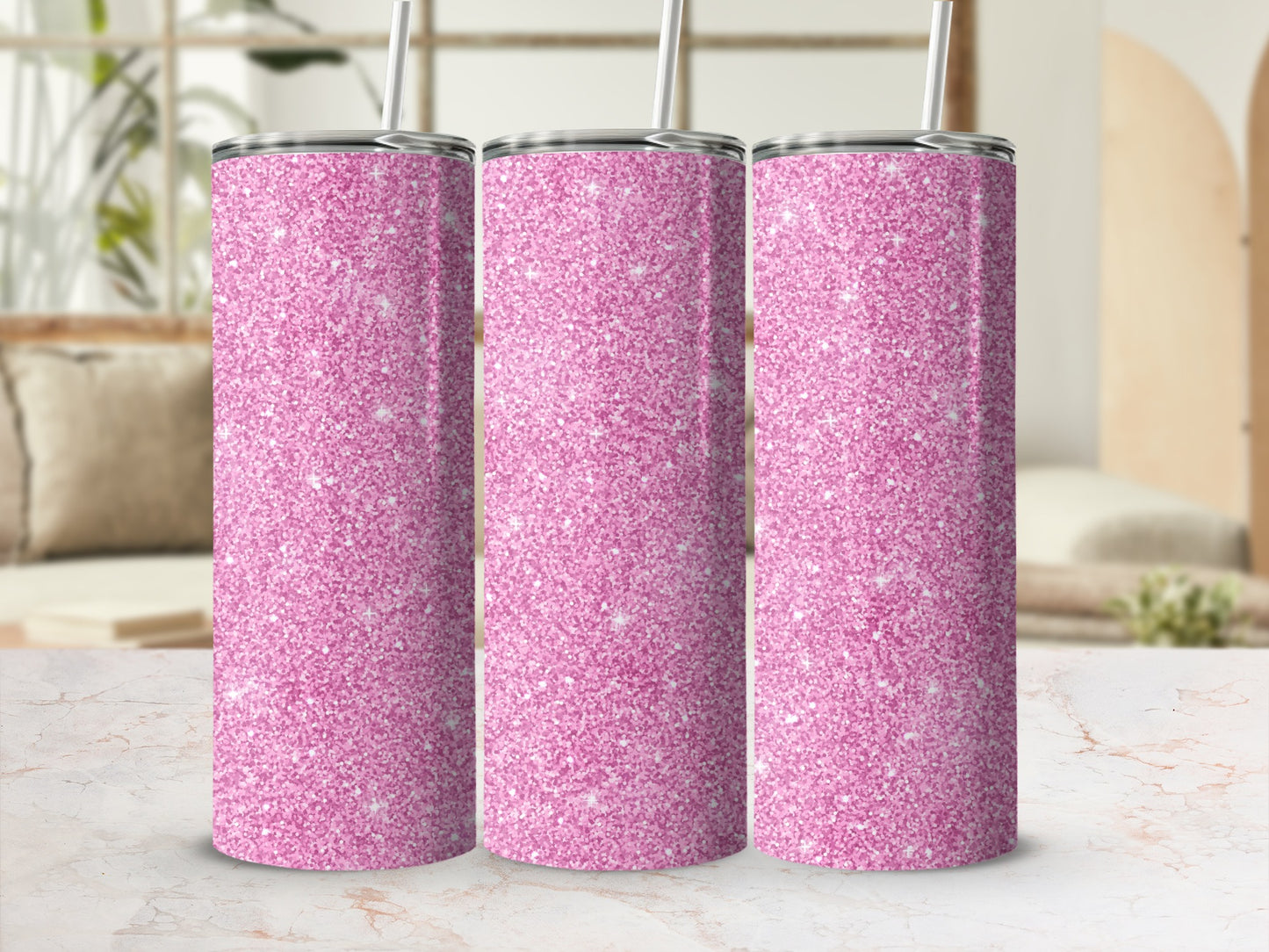Three pink glitter tumblers with straws stand in a row.