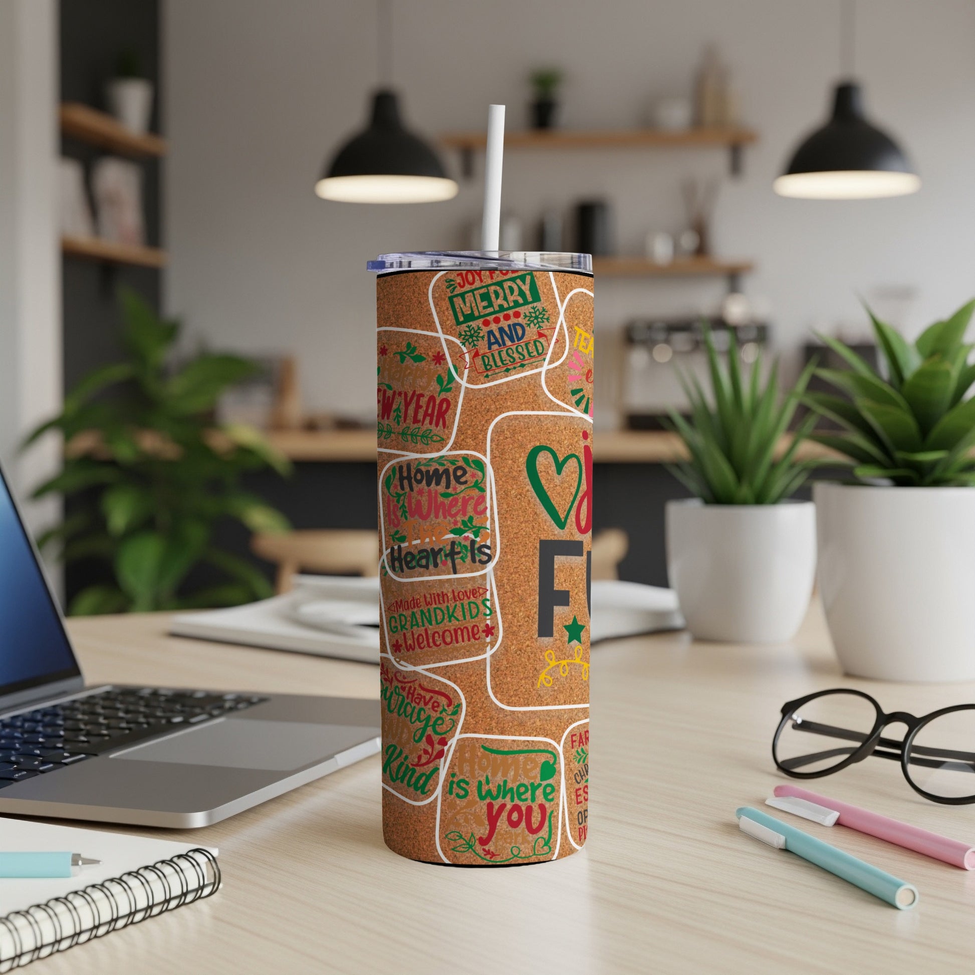 Tumbler with colorful holiday and family phrases on a cork-like background.
